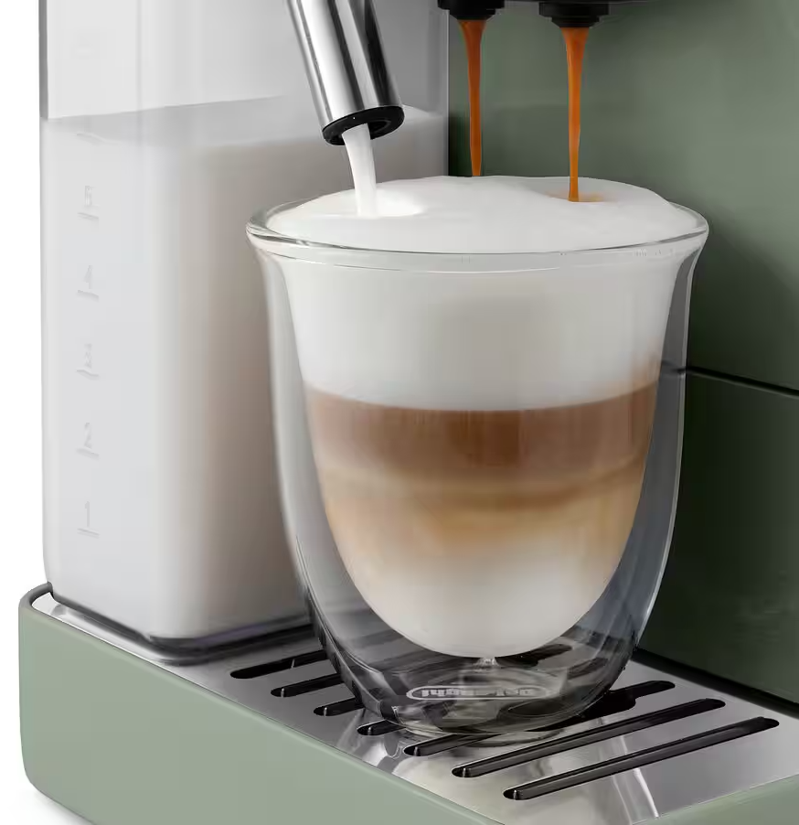 Egy kávéfőző tejet és kávét önt egy pohárba, rétegezett latte macchiatót készítve.