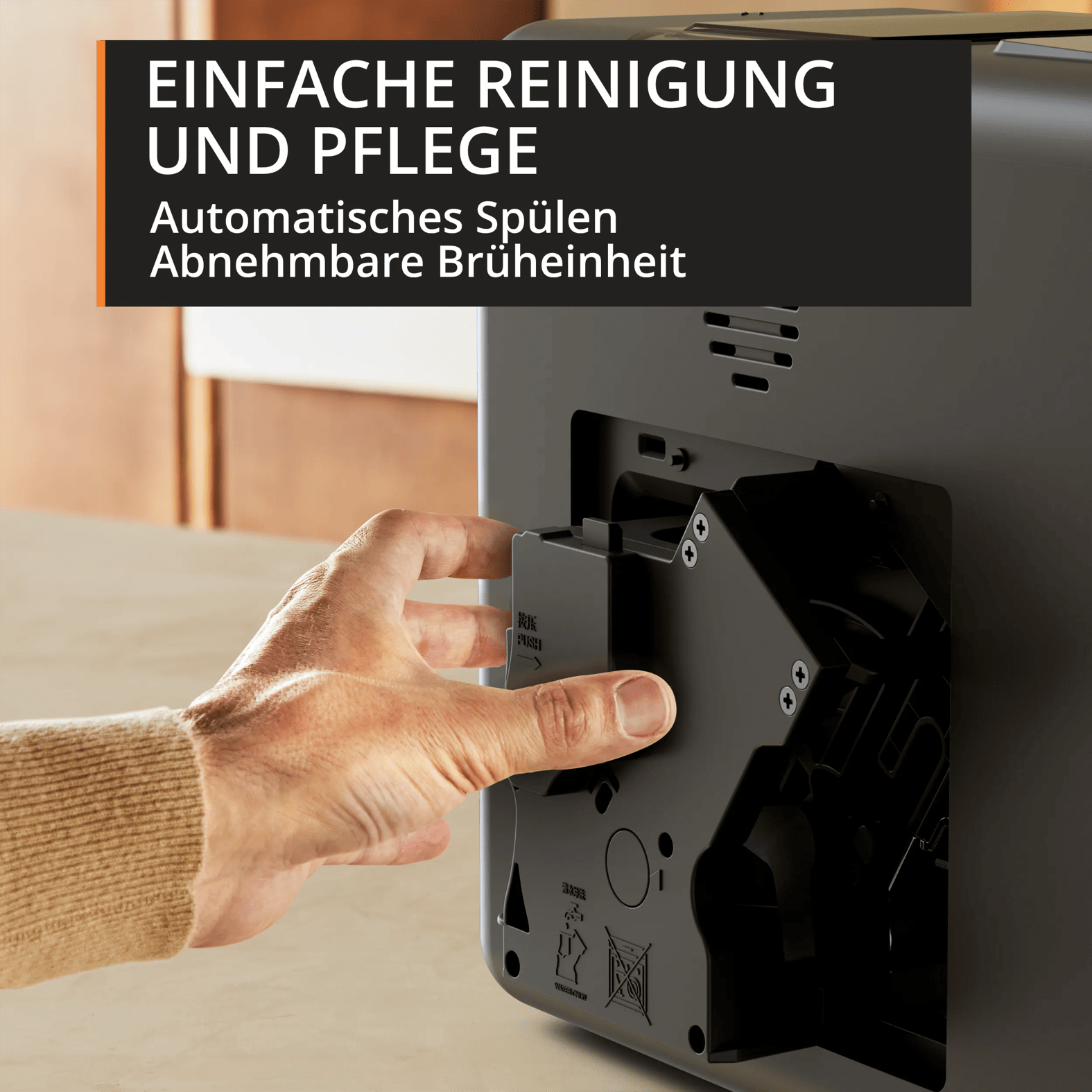Eine Hand setzt die abnehmbare Brüheinheit in eine Kaffeemaschine ein.