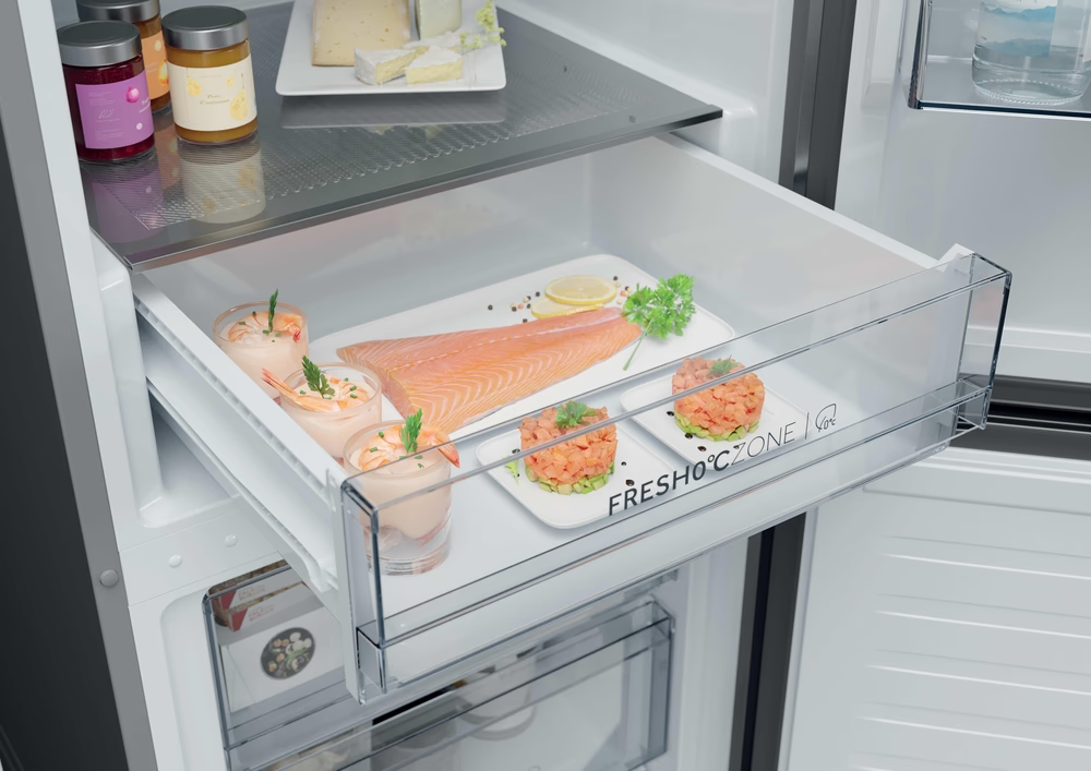 Egy nyitott hűtőfiók, FreshZone felirattal, friss lazacot, rákpoharakat és tatárt tartalmaz.