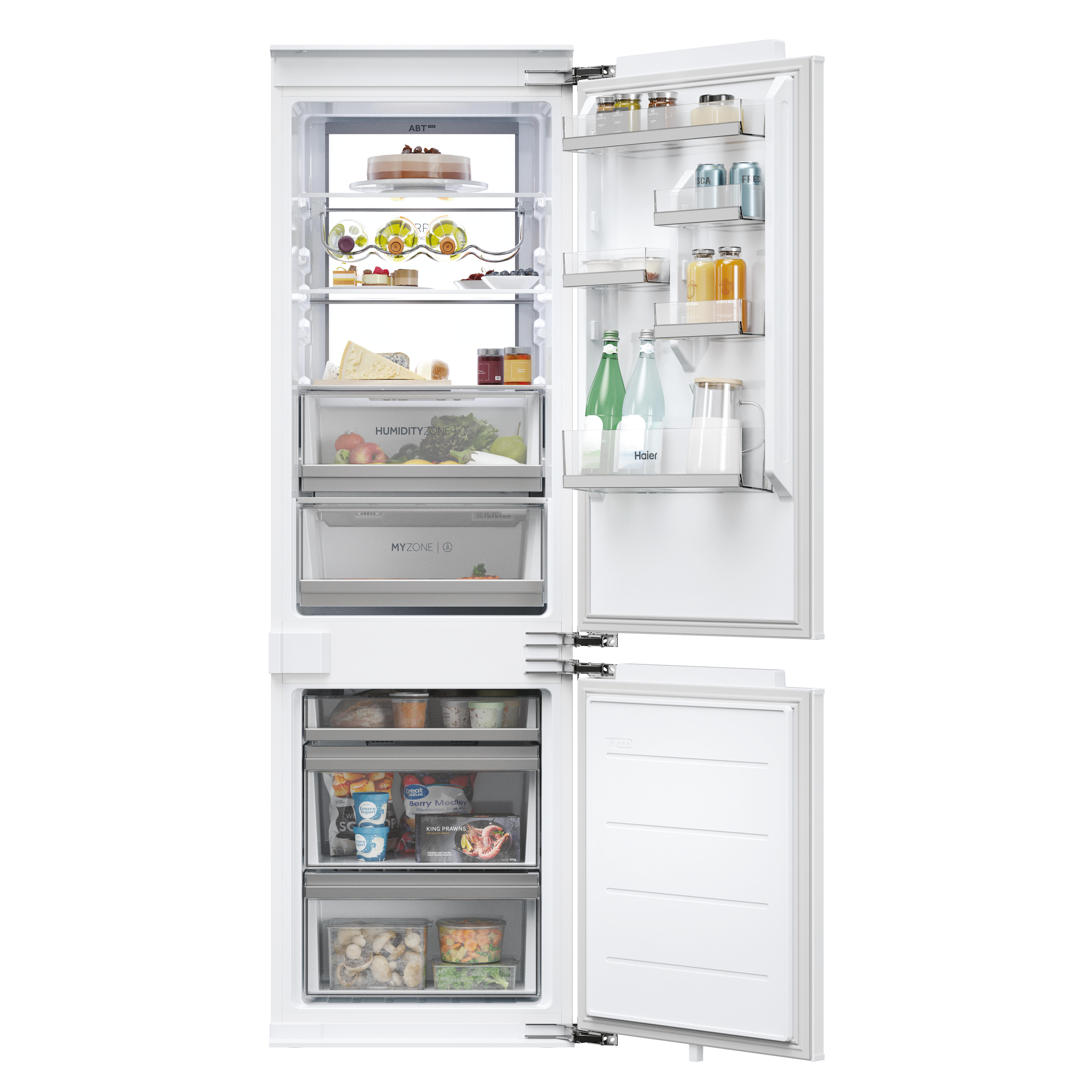Ein offener weißer Kühlschrank, gefüllt mit Lebensmitteln, Getränken und Obst auf Regalen.