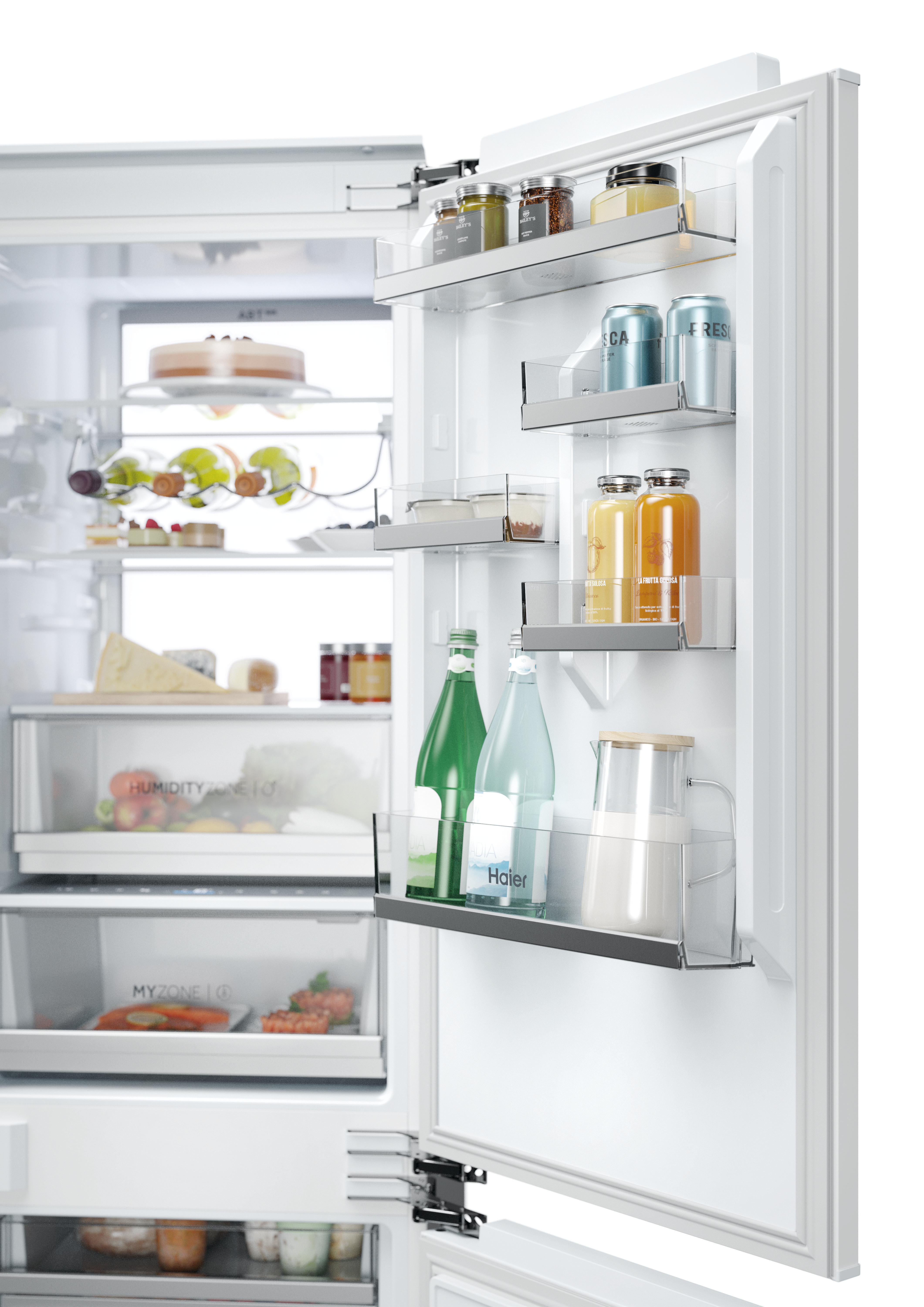 Ein weißer Kühlschrank mit geöffneter Tür, gefüllt mit gut organisierten Lebensmitteln, Flaschen und Getränken.