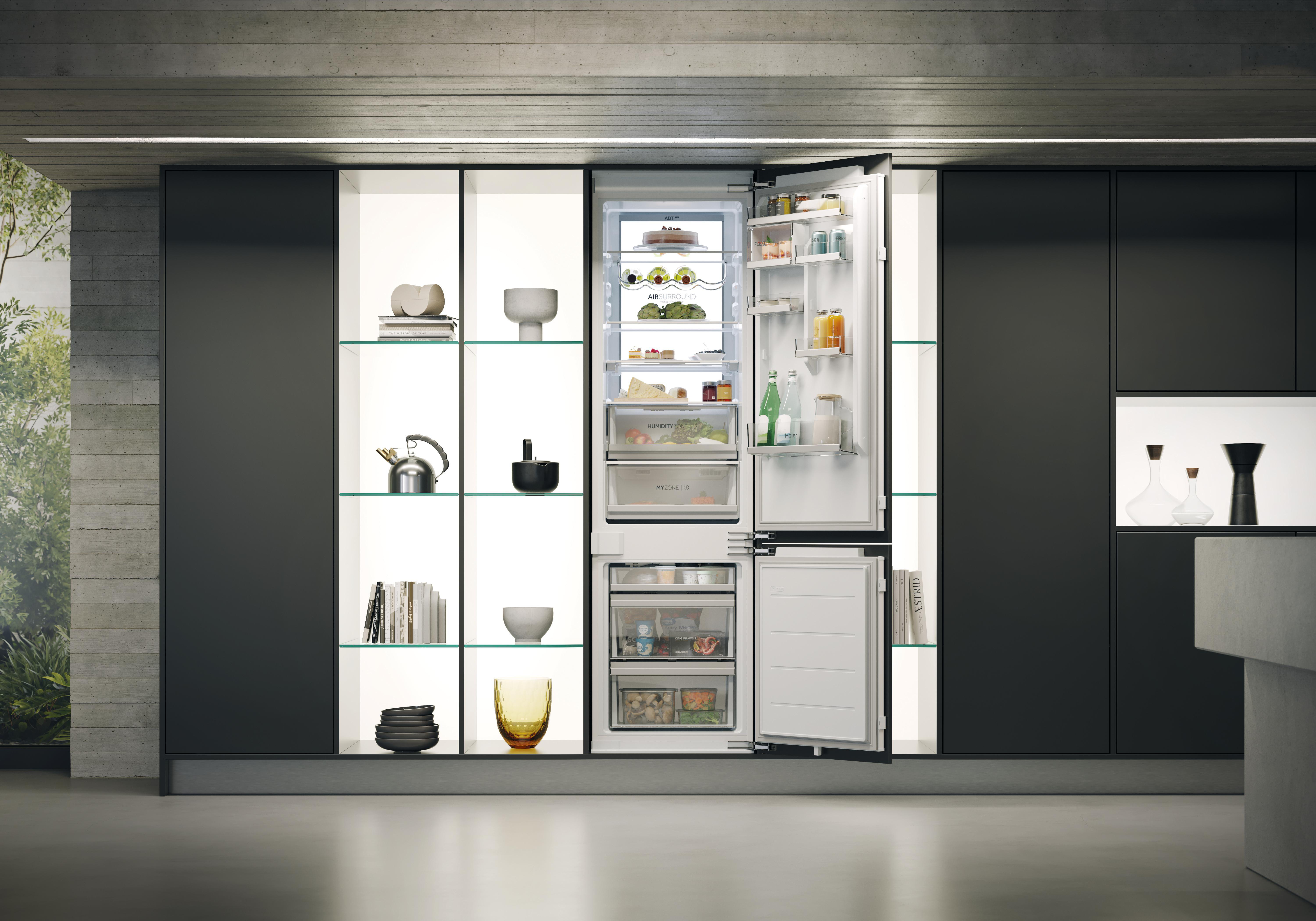 Offener Kühlschrank in moderner, dunkler Küche mit beleuchteten Regalen und Dekoration.