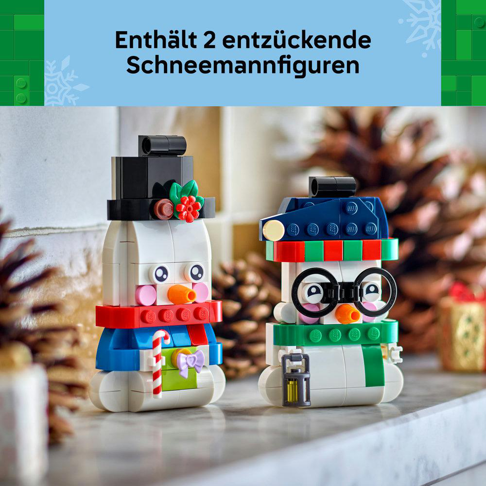 Zwei LEGO Schneemänner mit Hüten und Schals auf einem Tisch mit Tannenzapfen.