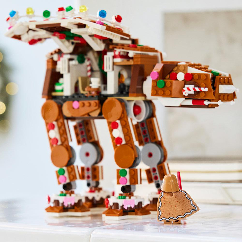 Ein detailliertes Lebkuchen-AT-AT-Modell aus Lego-Steinen mit einer kleinen Lebkuchen-Figur davor.