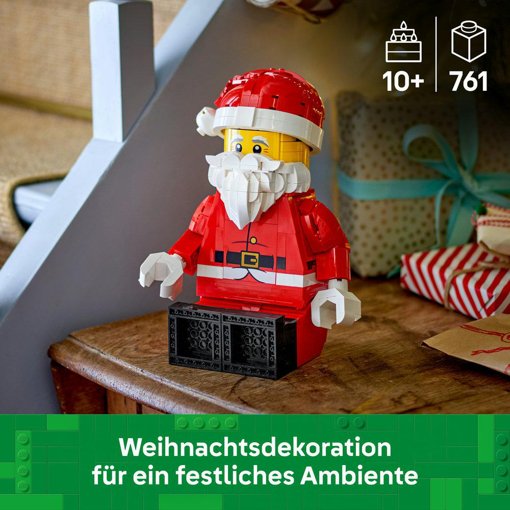 Eine LEGO Weihnachtsmann-Figur sitzt auf einem Holztisch, umgeben von Geschenken.