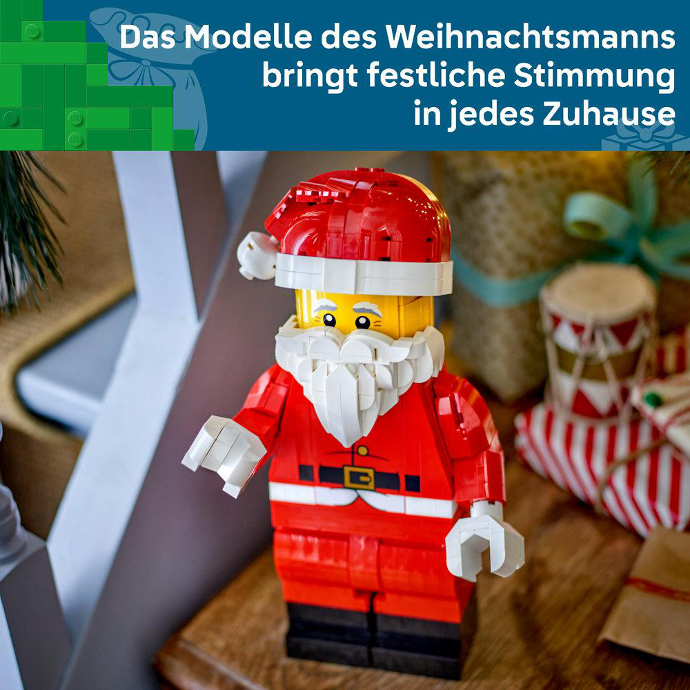 Ein Lego-Weihnachtsmann-Modell mit rotem Anzug und weißem Bart steht vor Geschenken.