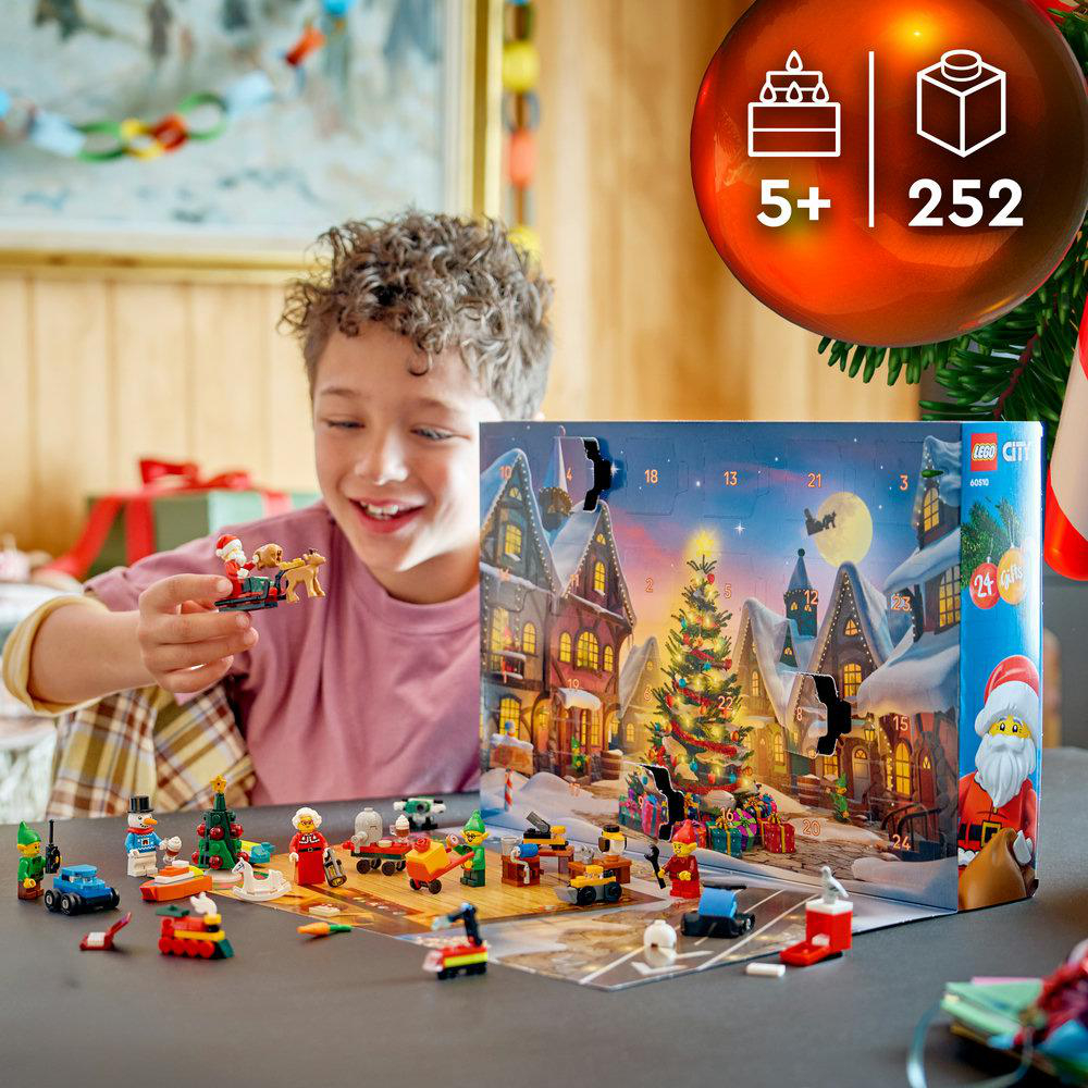 Ein lächelnder Junge spielt mit Lego City Adventskalender-Spielzeug.