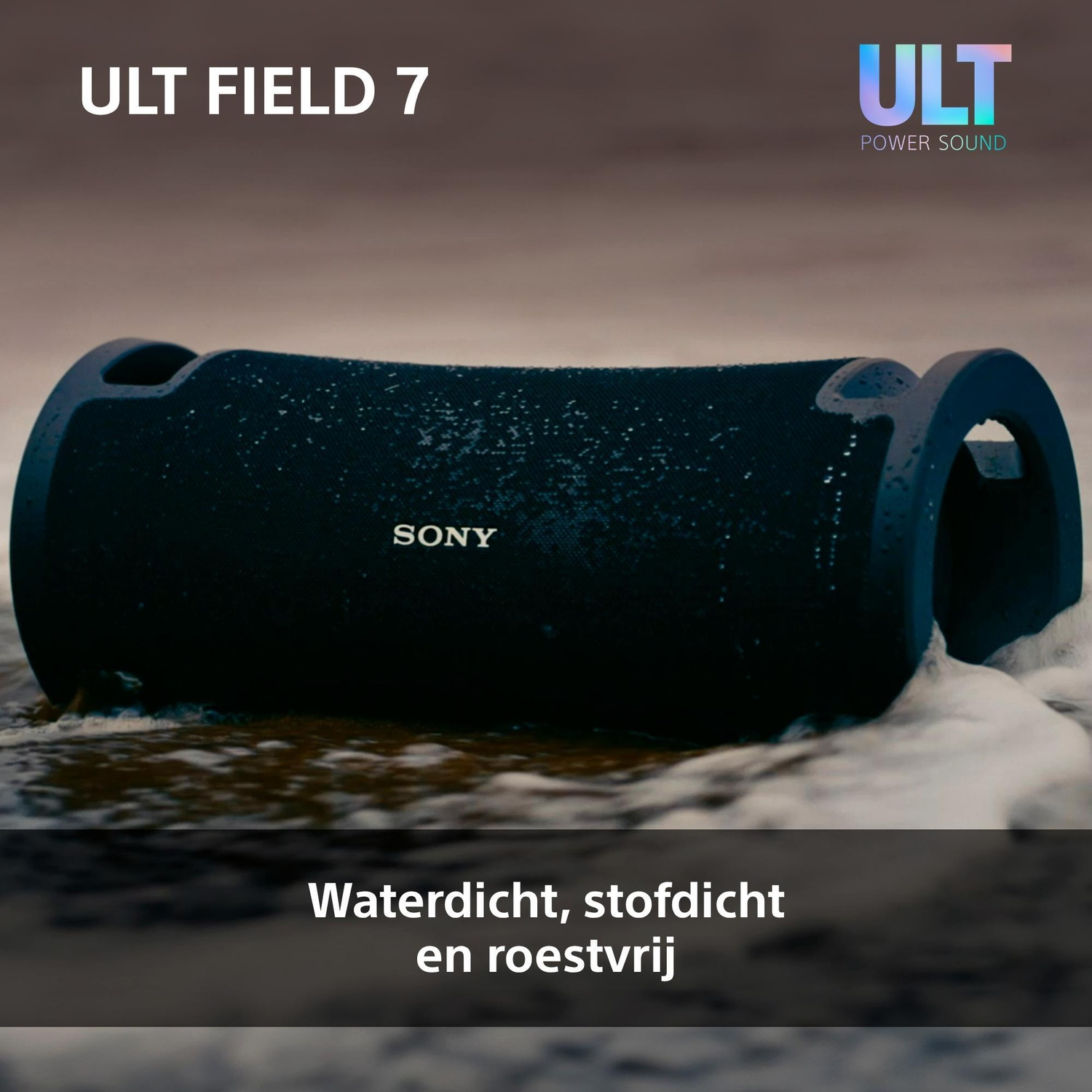 A black Sony ULT FIELD 7 wireless speaker rests on wet sand with sea foam around it.