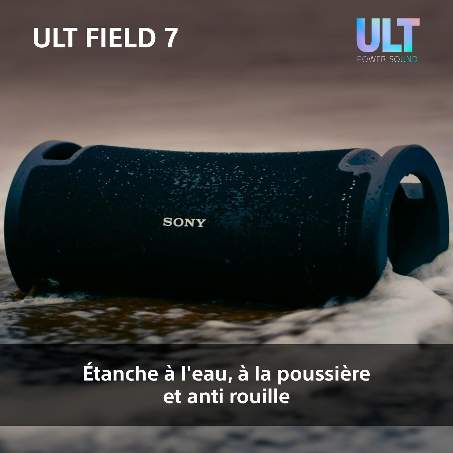 Une enceinte noire Sony ULT Field 7 repose sur une plage de sable mouillé près de l'écume.