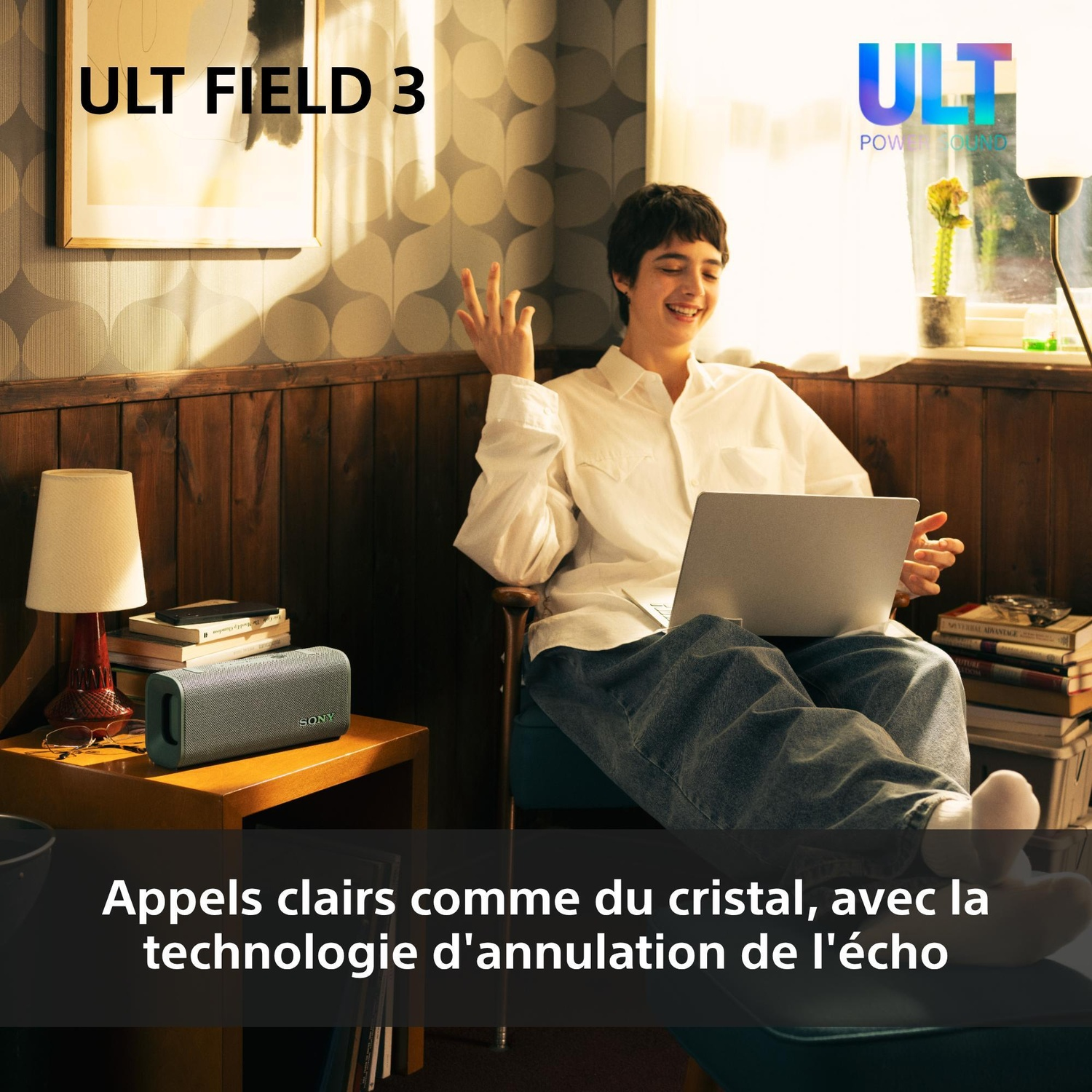 Personne en chemise blanche assise dans un fauteuil avec un ordinateur portable, près d'une enceinte Sony.