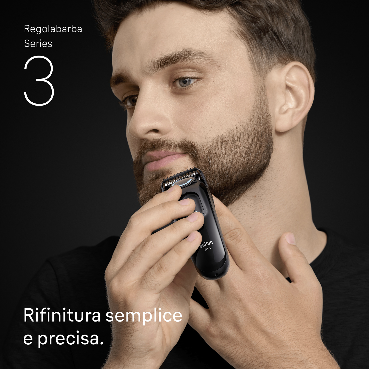 Un uomo regola la barba con un tagliabarba nero Braun su sfondo scuro.