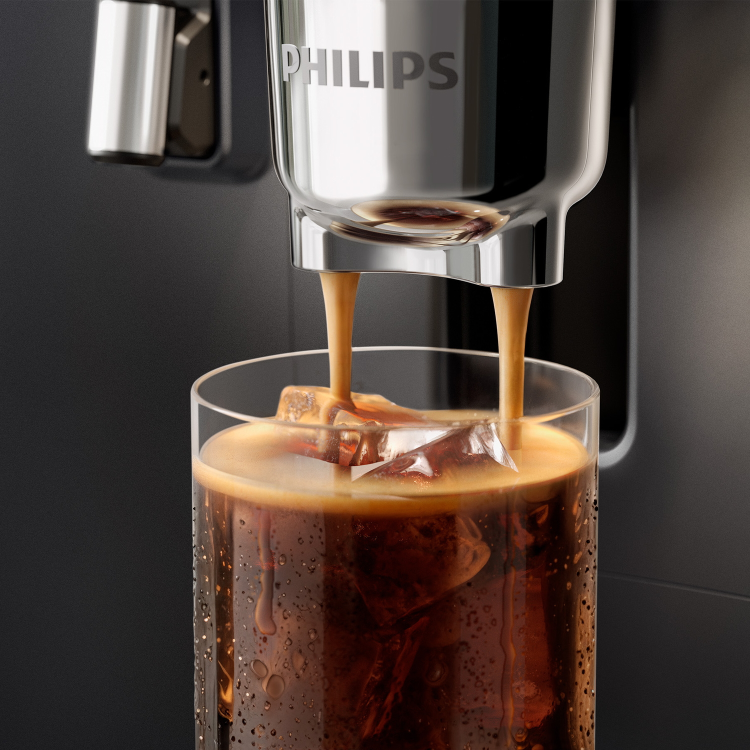 Freshly brewed coffee pours from a Philips machine into a glass filled with ice cubes.