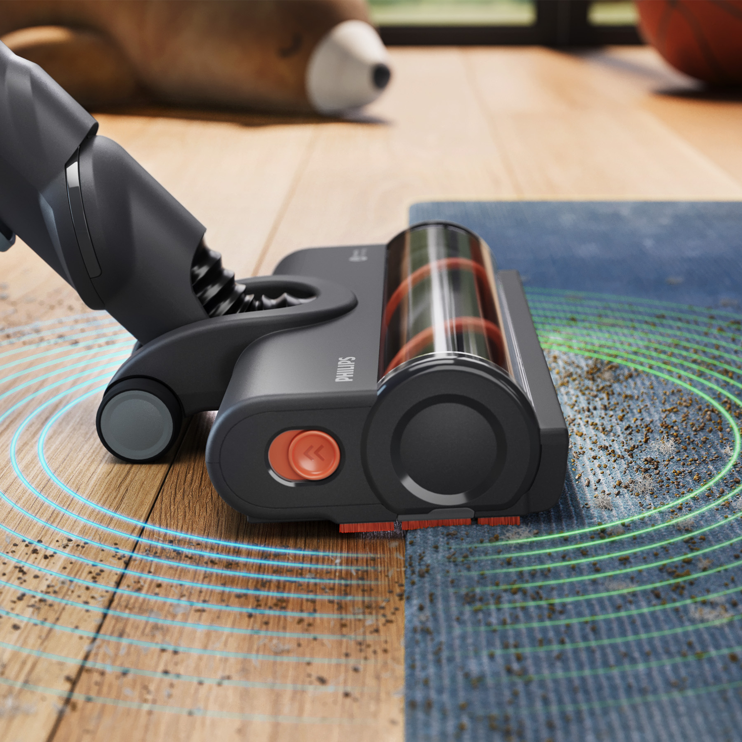 A grey Philips vacuum cleans dirt from hardwood floor and rug, shown with visual suction waves.