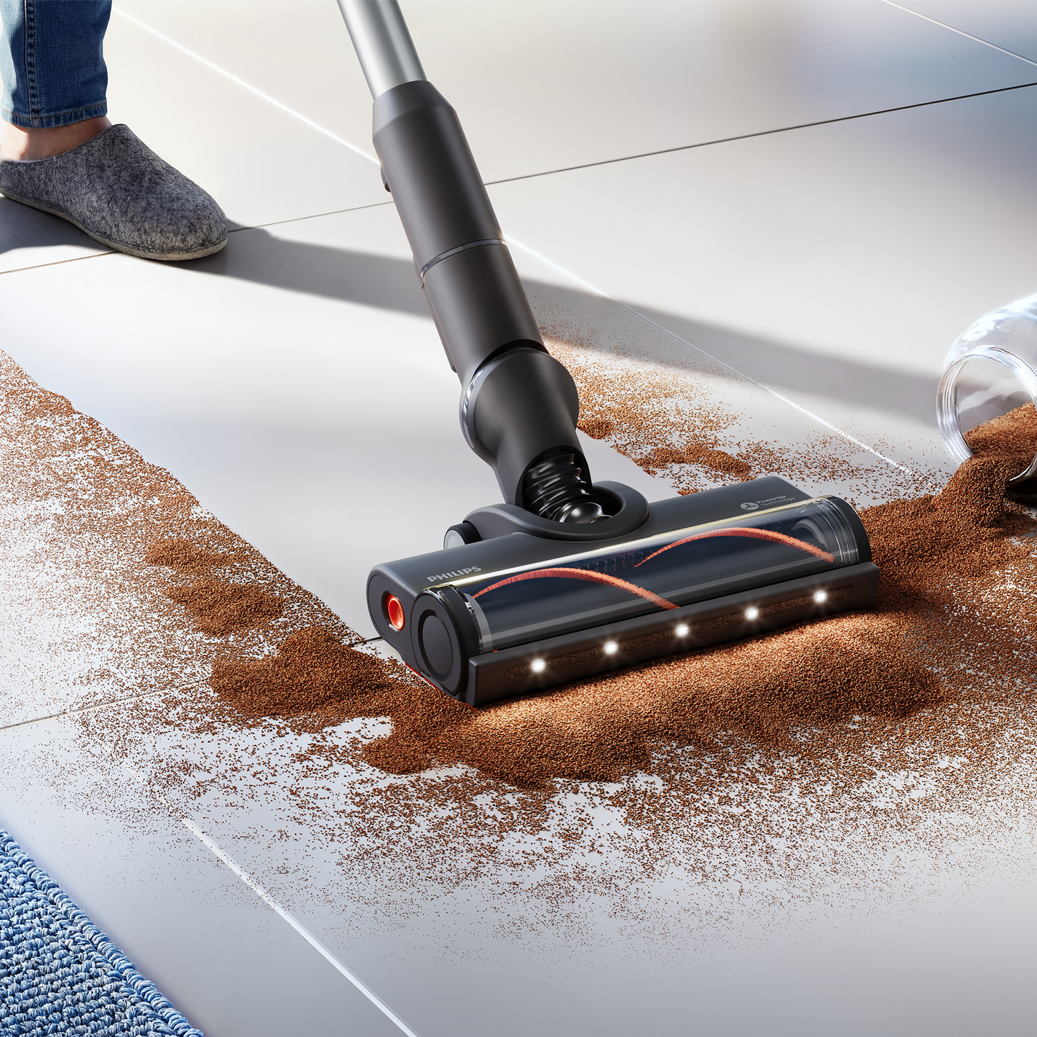 A cordless vacuum cleaner cleans up coffee grounds from a light-colored tiled floor.