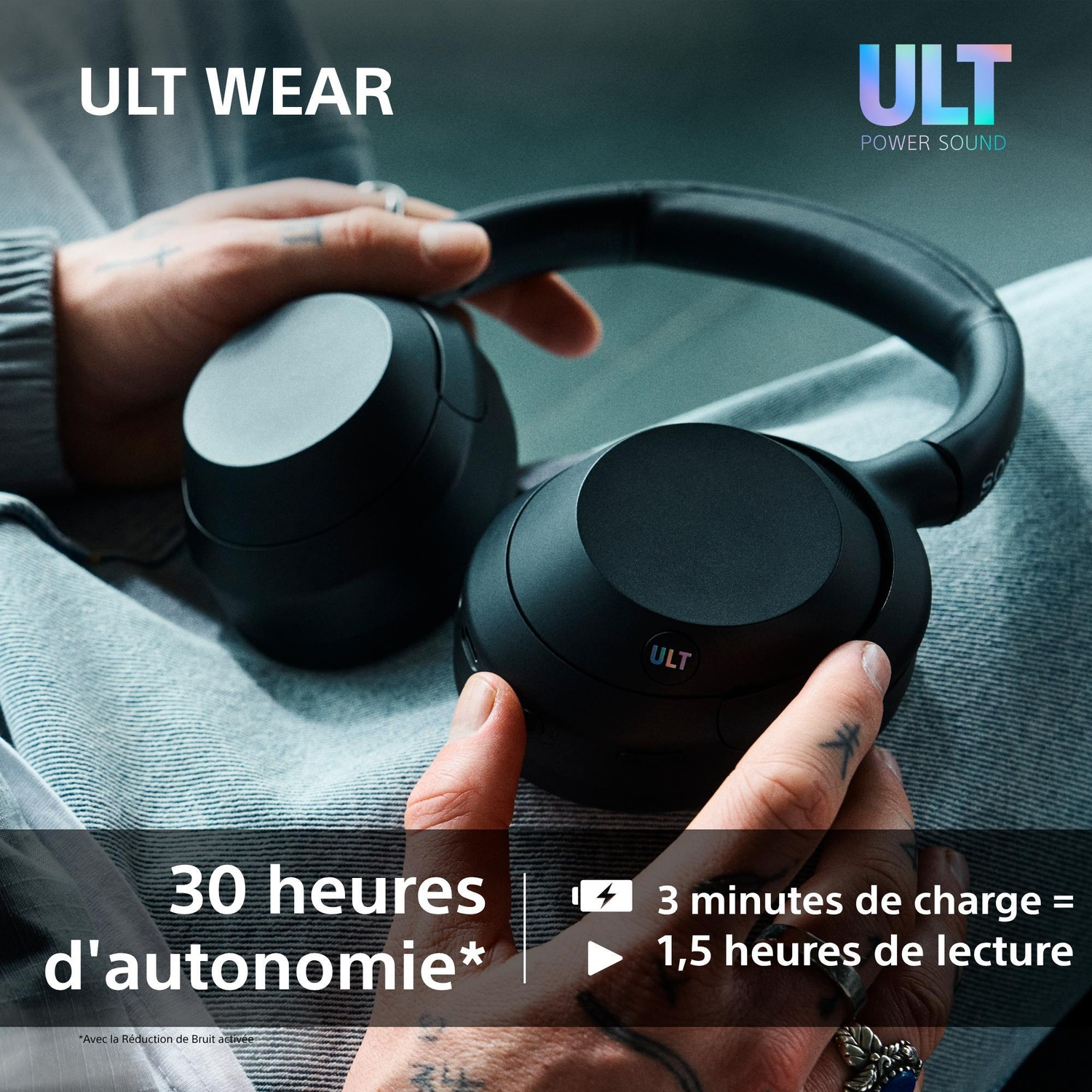 Une personne tient des écouteurs noirs ULT WEAR, avec du texte sur l'autonomie et la charge rapide.