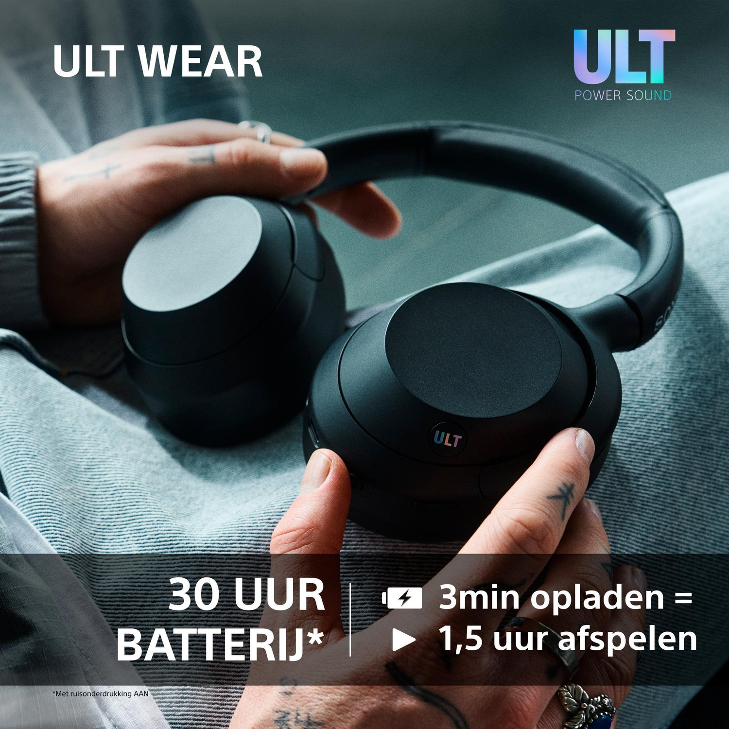 A person holds black ULT WEAR headphones with text about 30 hours battery life and 3min charge for 1.5 hours.