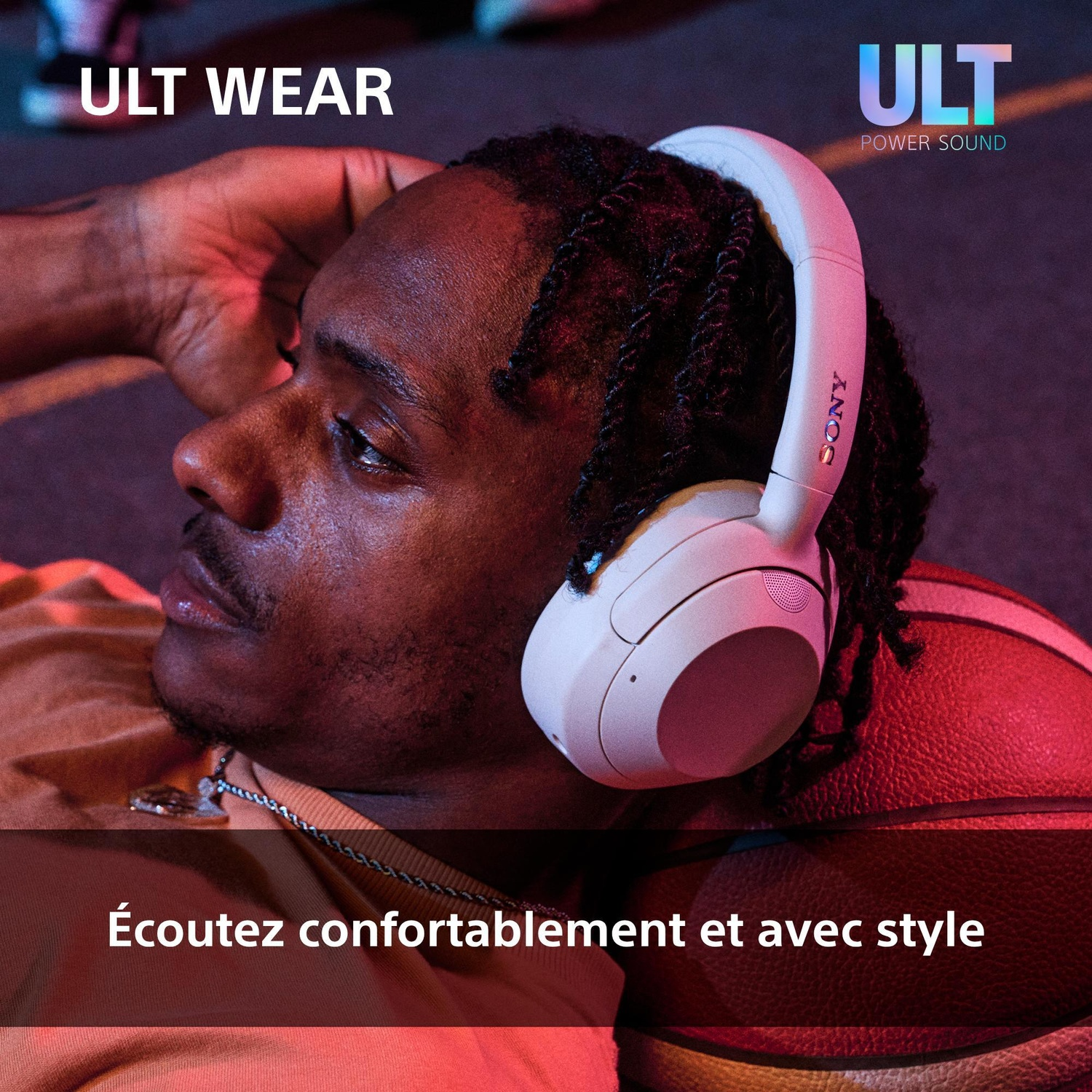 Un homme avec un casque Sony blanc se détend en s'appuyant sur un ballon.