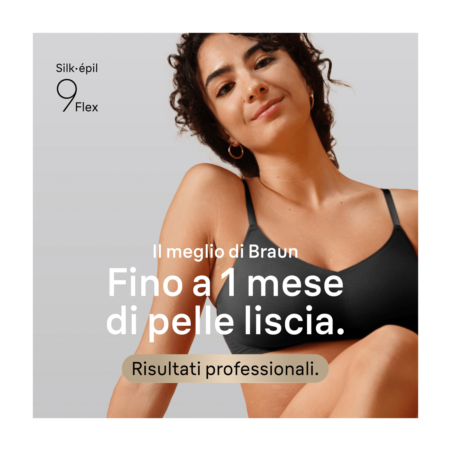 Una donna sorridente con capelli ricci scuri indossa un top nero, con testo sulla pelle liscia.