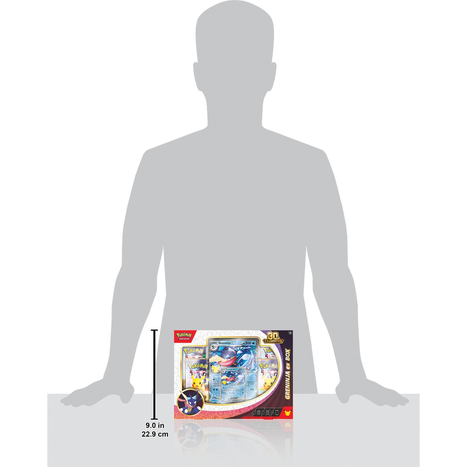 Grijze menselijke silhouet naast een Pokémon Greninja ex doos met een hoogte van 22,9 cm.