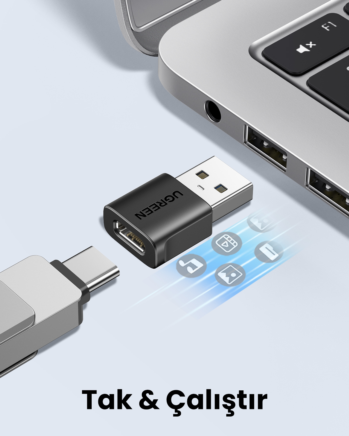 Veri aktarım simgeleri gösteren bir dizüstü bilgisayar yanında Ugreen USB adaptör.