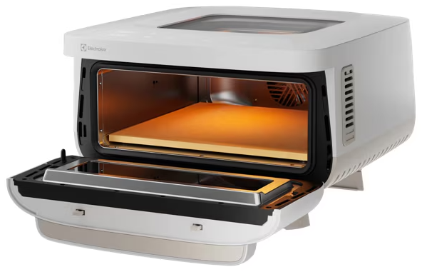 Fehér Electrolux kompakt sütő nyitott ajtóval és pizzakővel a megvilágított belső térben.