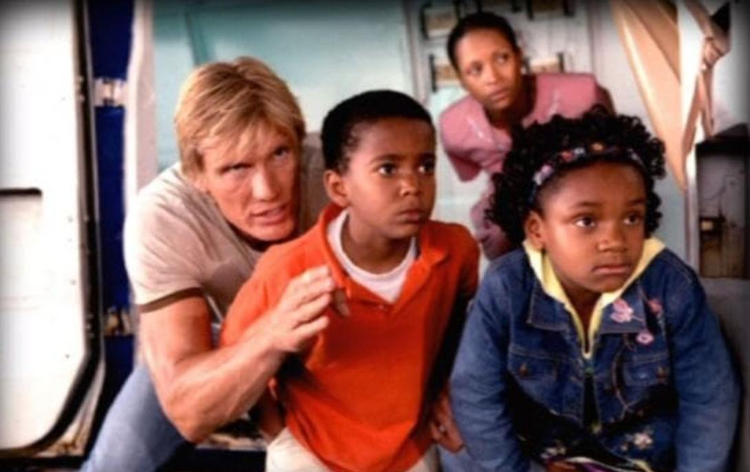 Ein blondhaariger Mann und drei Kinder schauen besorgt in eine Richtung.