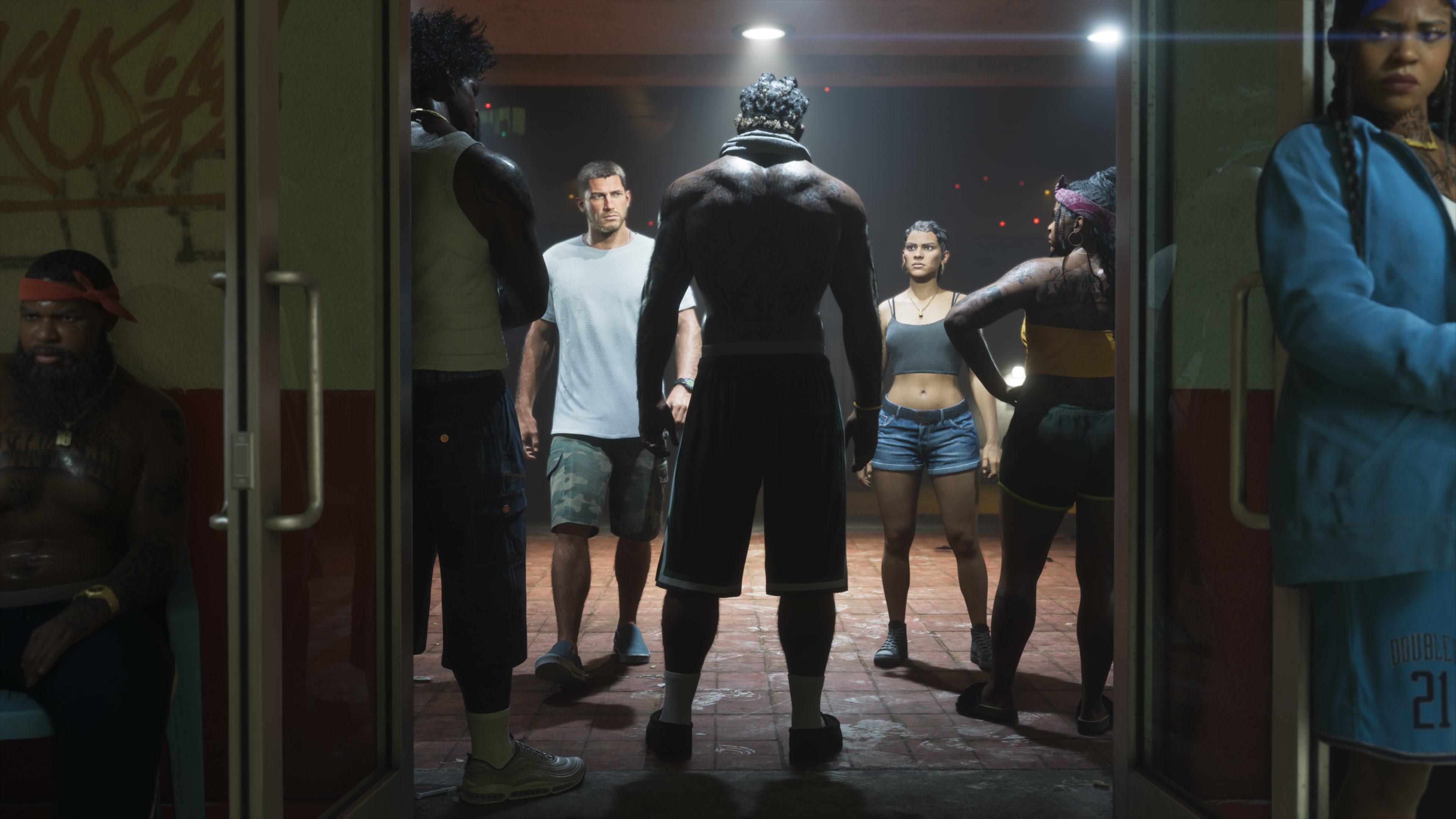 Grupa różnorodnych osób stoi w drzwiach słabo oświetlonego pokoju.