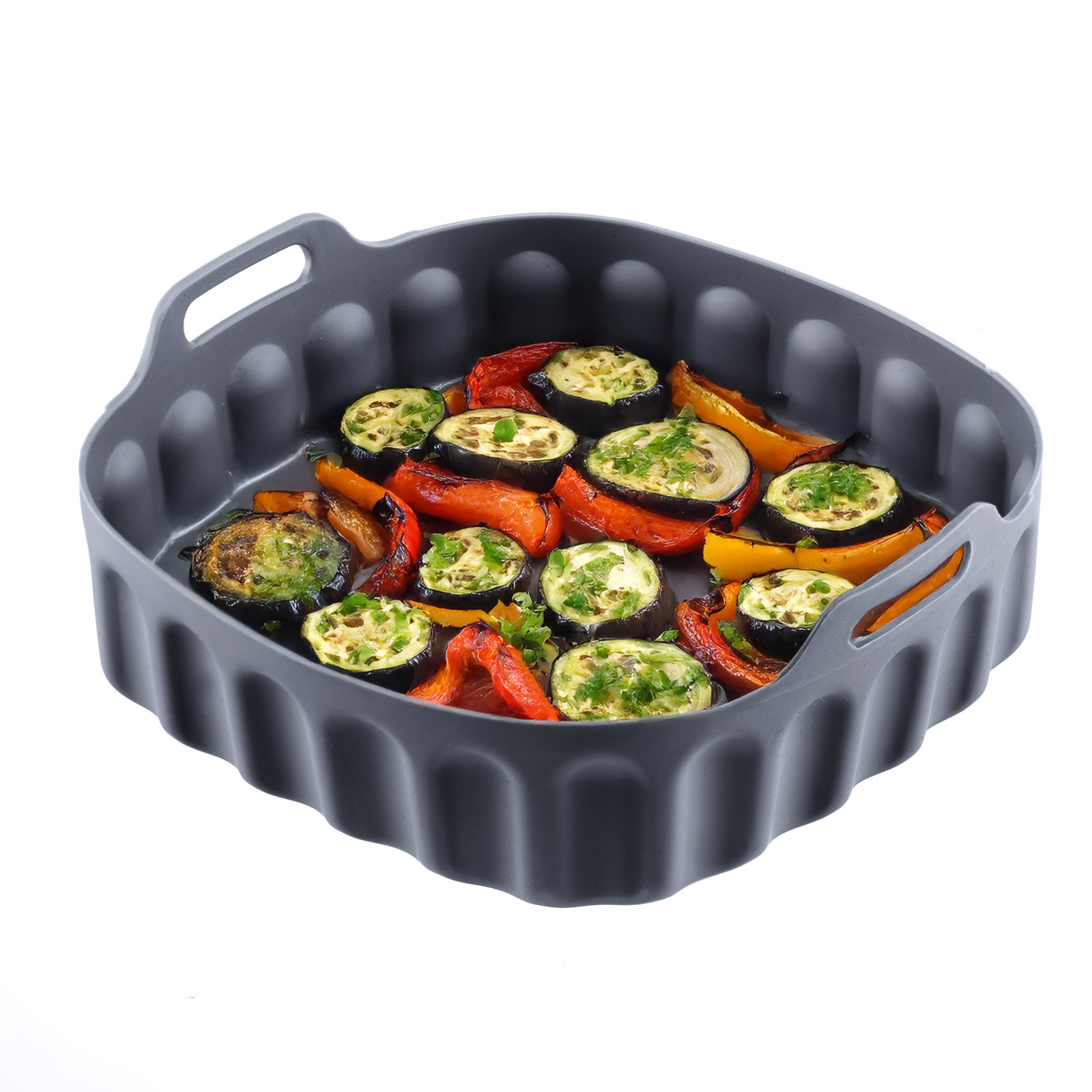 Gebratene Zucchini- und Paprikascheiben mit Kräutern in einer dunkelgrauen Silikonbackform.