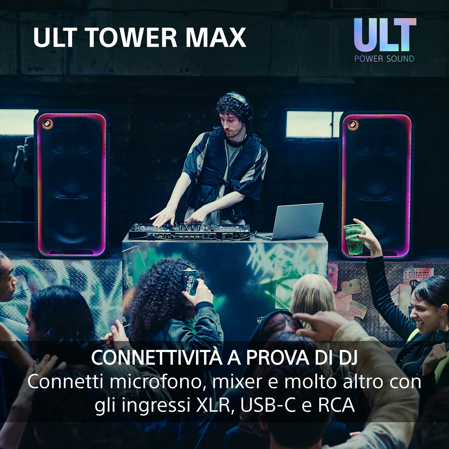 DJ che si esibisce con grandi altoparlanti luminosi e folla in un club.