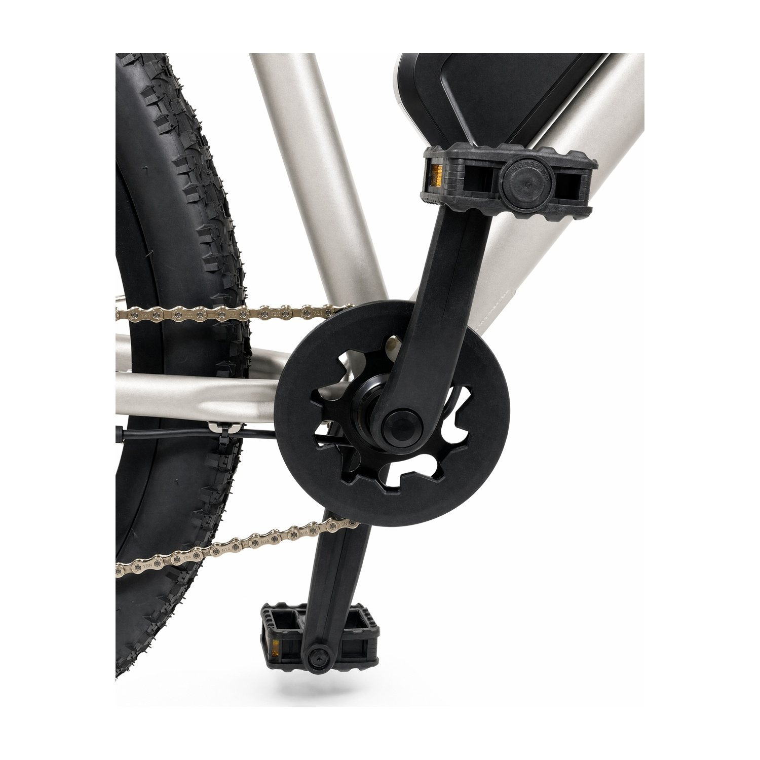 Primo piano di guarnitura, pedali e catena di una e-bike argentata su sfondo bianco.