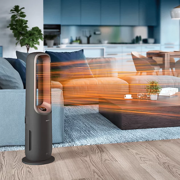 Egy elegáns sötétszürke toronyventilátor meleg narancssárga légáramot fúj egy modern nappaliban.
