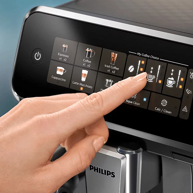 Egy kéz egy modern Philips kávégép digitális érintőképernyőjét használja.