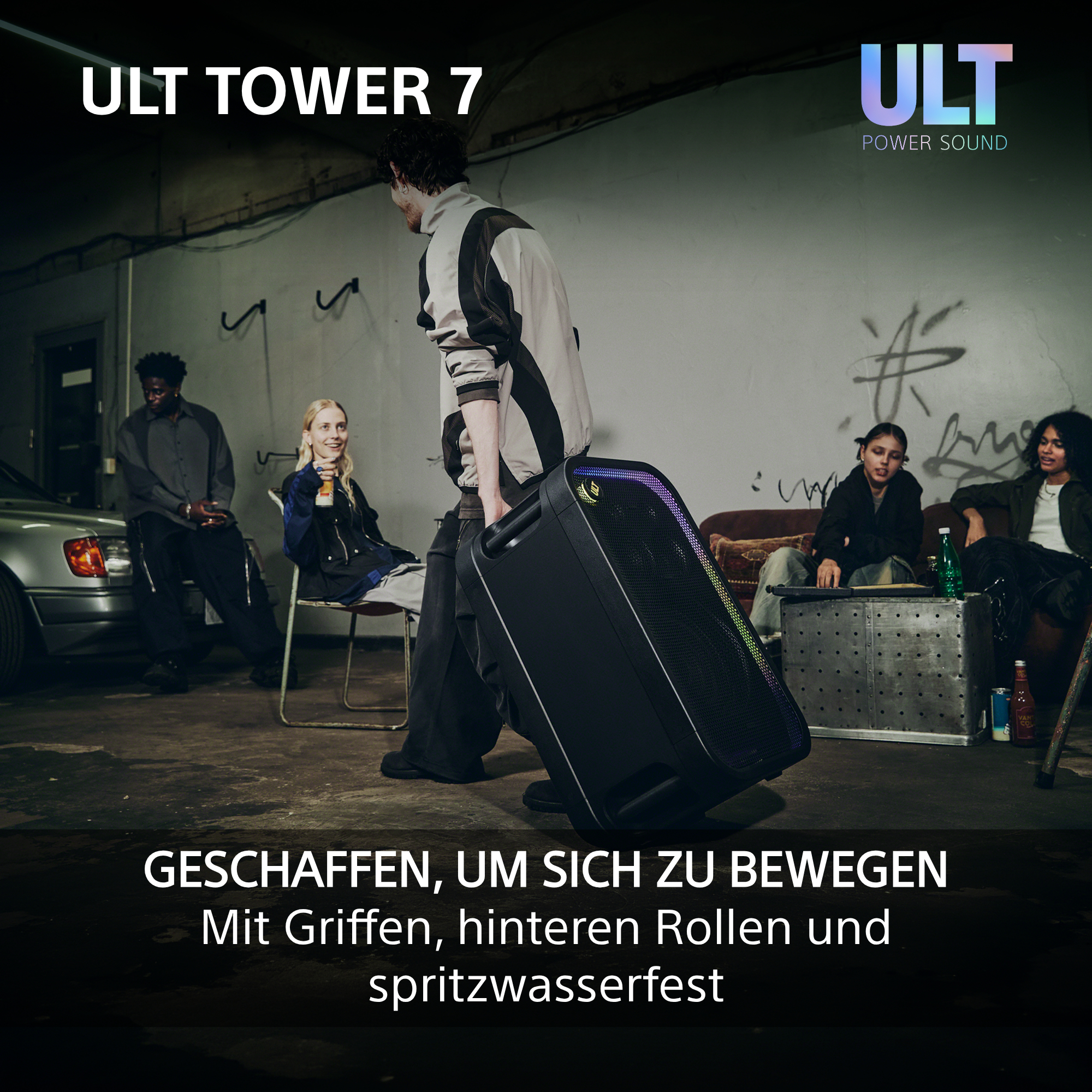 Ein junger Mann zieht einen großen, mobilen ULT Tower 7 Lautsprecher in einem urbanen Raum mit Freunden.