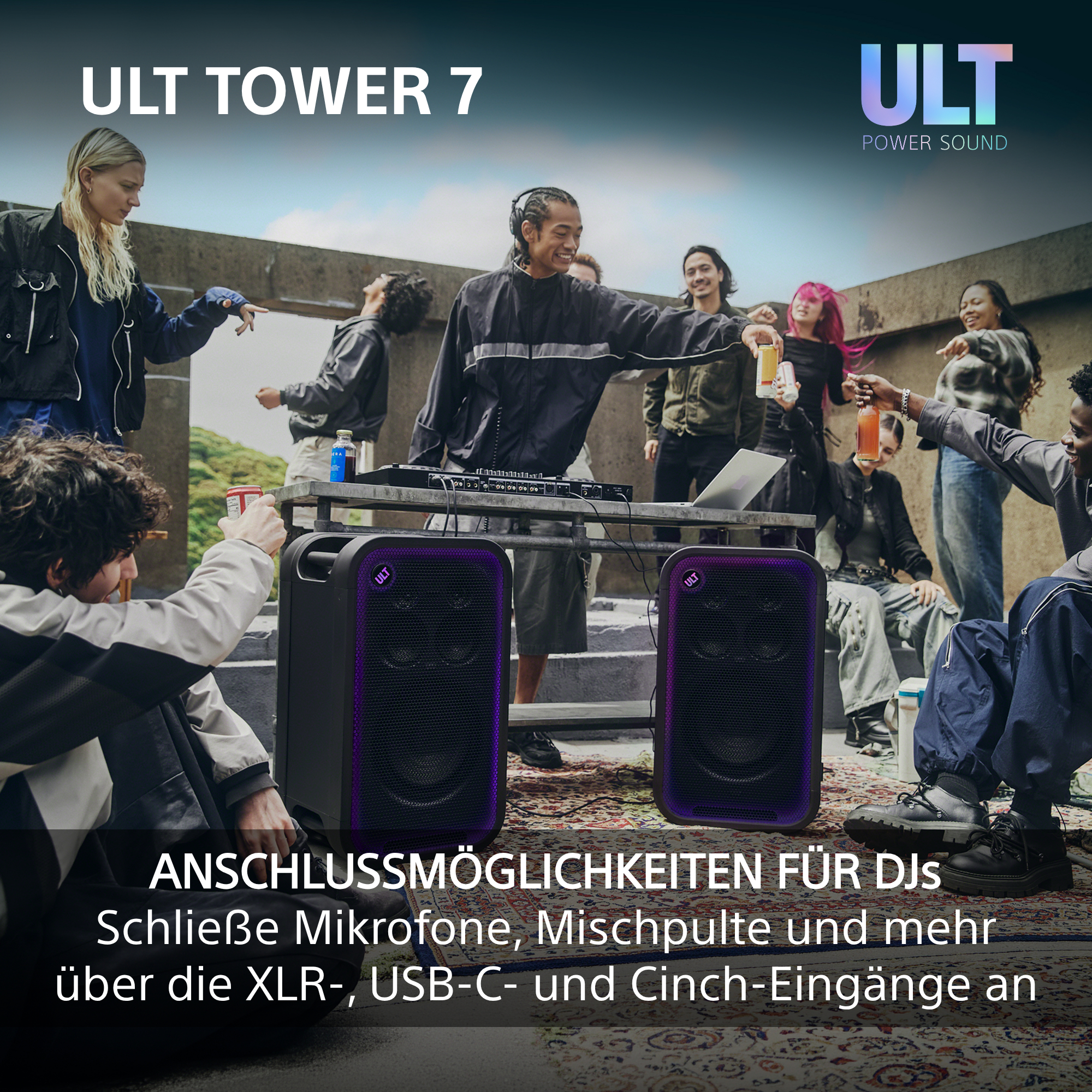 Gruppe von Freunden feiert auf einer Dachterrasse mit zwei großen Lautsprechern, DJ-Pult und Getränken.