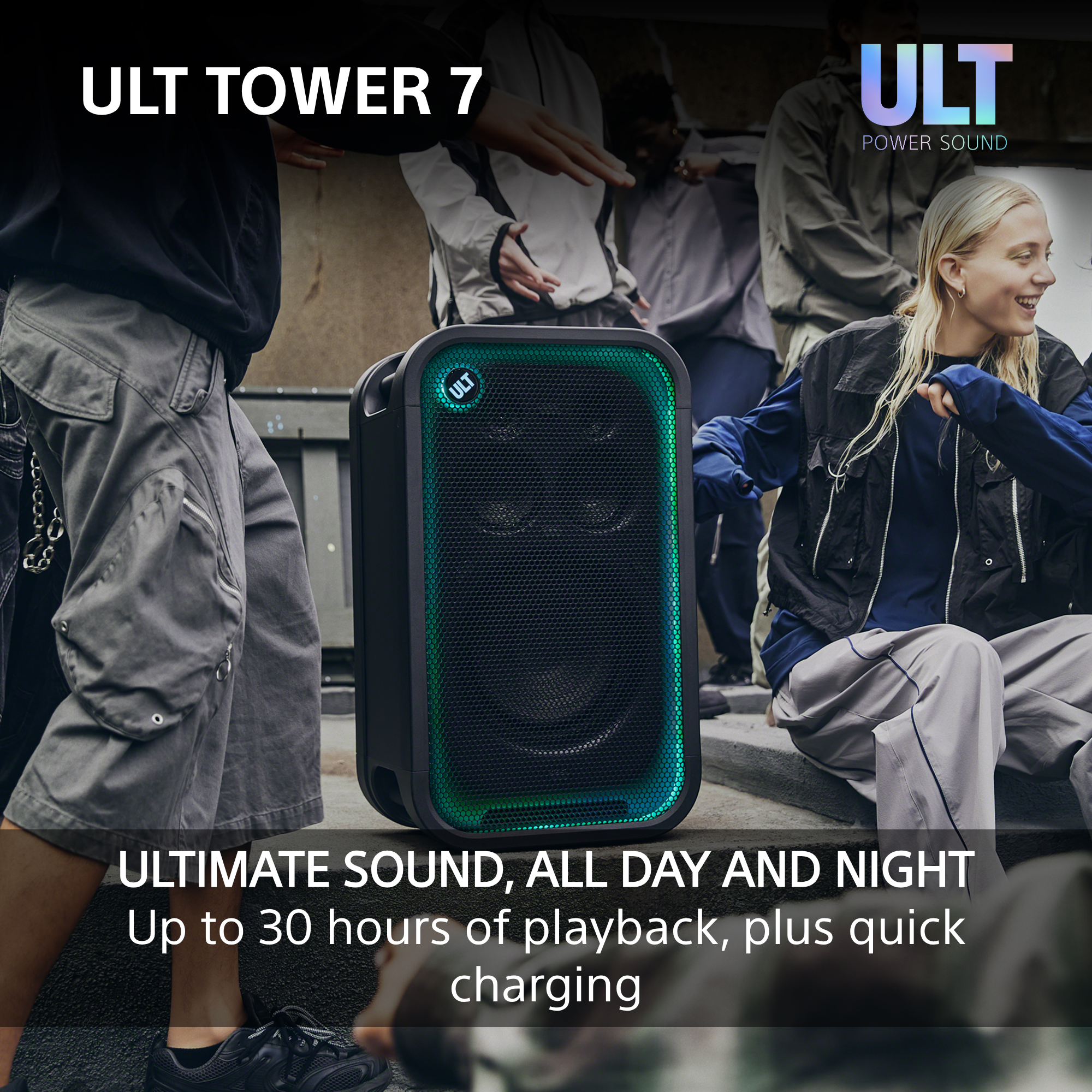 Ein ULT Tower 7 Lautsprecher steht im Freien mit grünem Leuchten, umgeben von tanzenden Menschen.