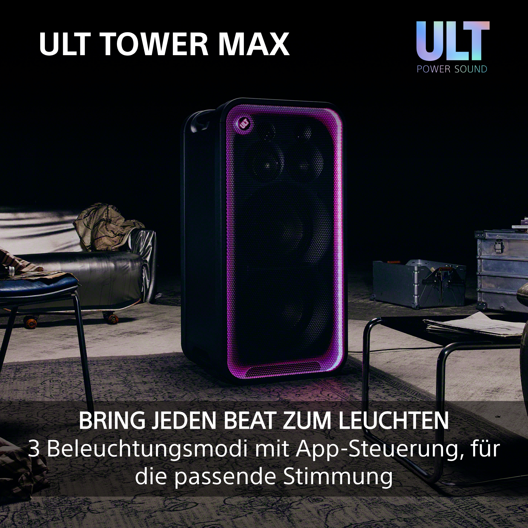 Ein schwarzer ULT TOWER MAX Lautsprecher leuchtet in einem gedimmten Raum mit Möbeln.