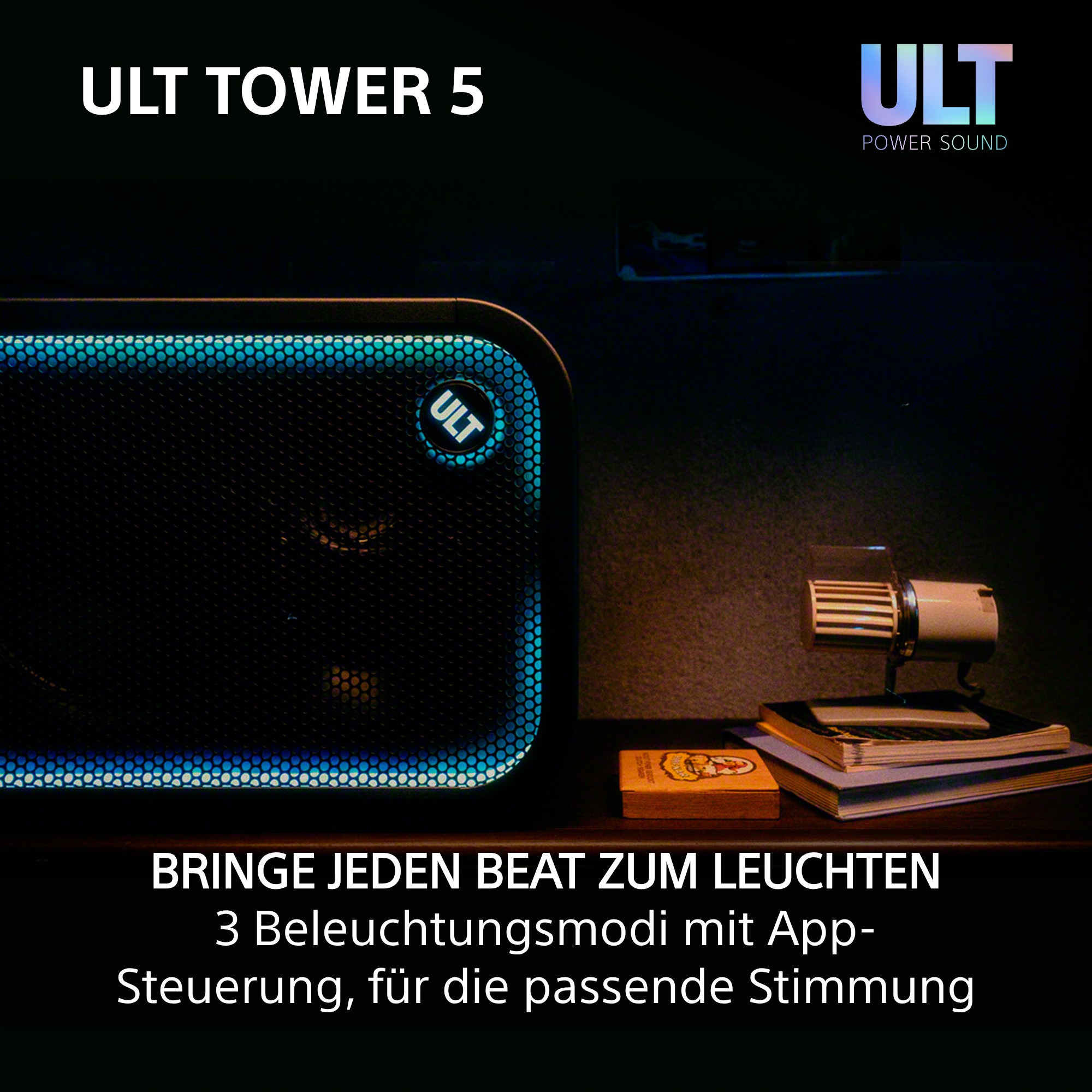 Ein schwarzer ULT TOWER 5 Lautsprecher mit blauem Licht auf dem Gitter, auf einem dunklen Holztisch.