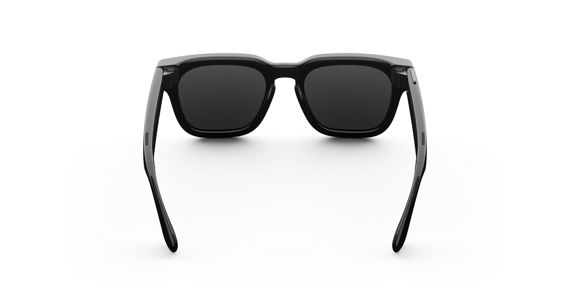 Gafas inteligentes negras iluminadas desde atrás sobre fondo oscuro.