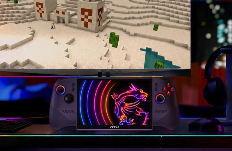 Una console portatile con logo MSI sotto un monitor che mostra un paesaggio desertico a blocchi.