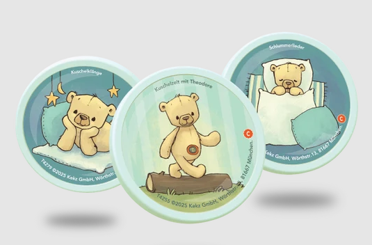 Drei runde Marken mit Zeichnungen von Teddybären in verschiedenen Szenen vor grauem Hintergrund.