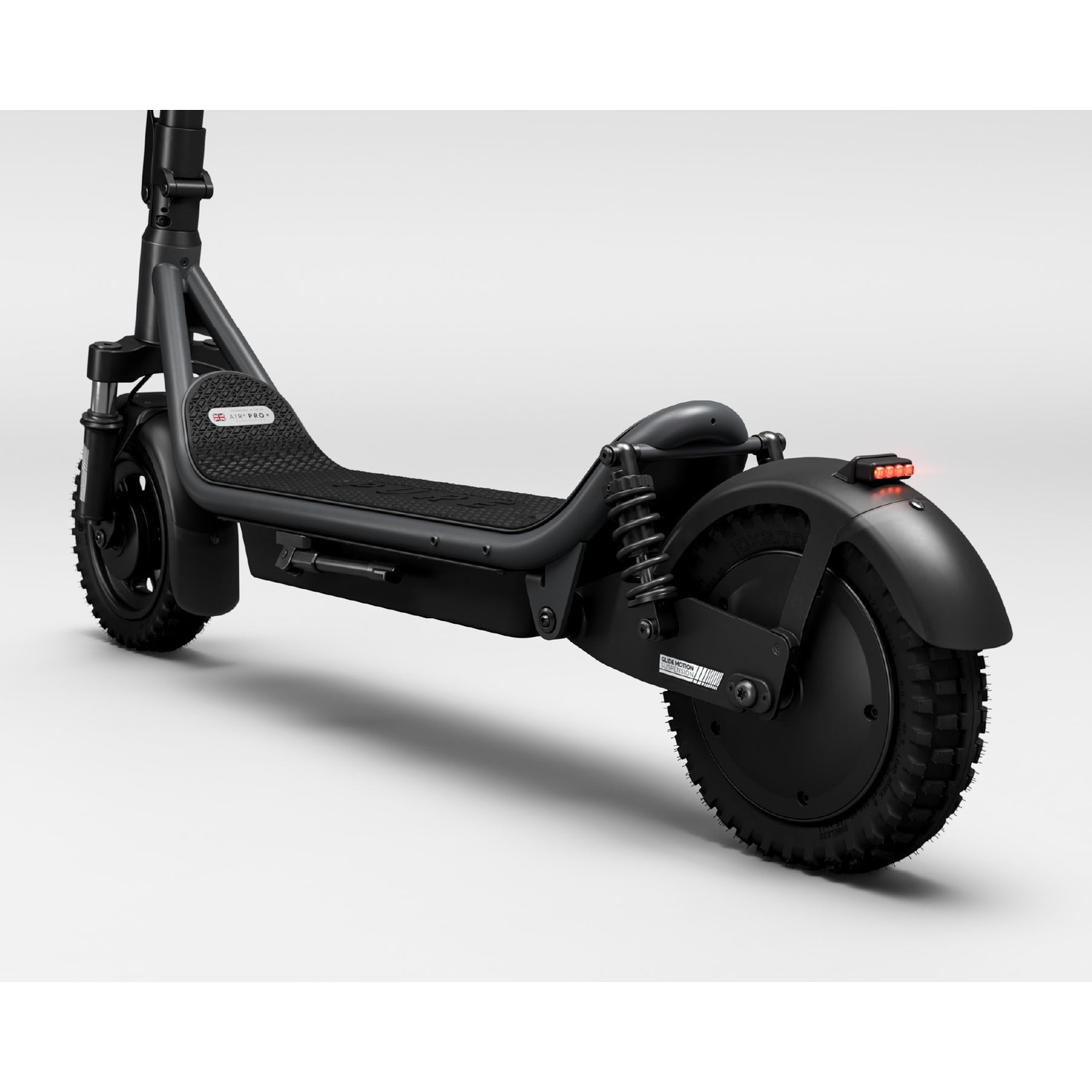 A black electric scooter with suspension springs, rugged tires, and a red taillight on a white background.