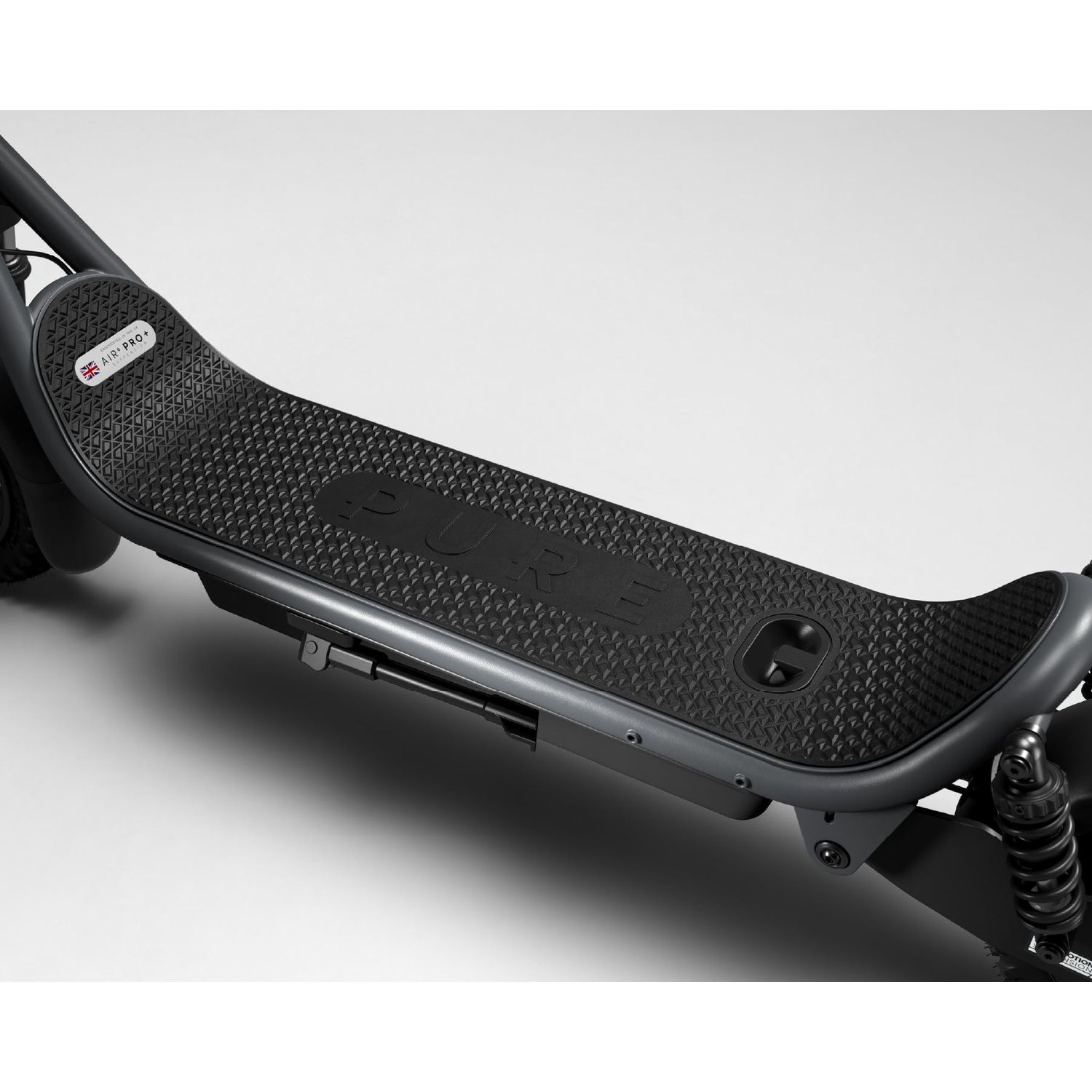 Close-up of a grey electric scooter's textured deck with the PURE logo against a white background.