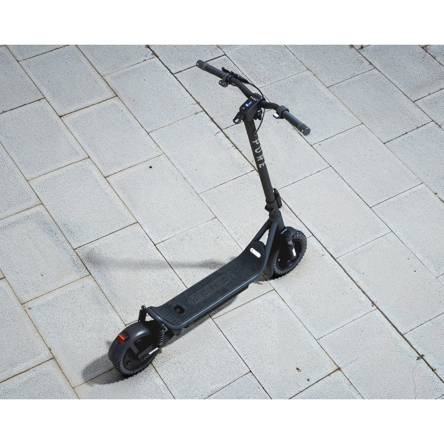 A black electric scooter parked on light-colored paving stones, viewed from above.