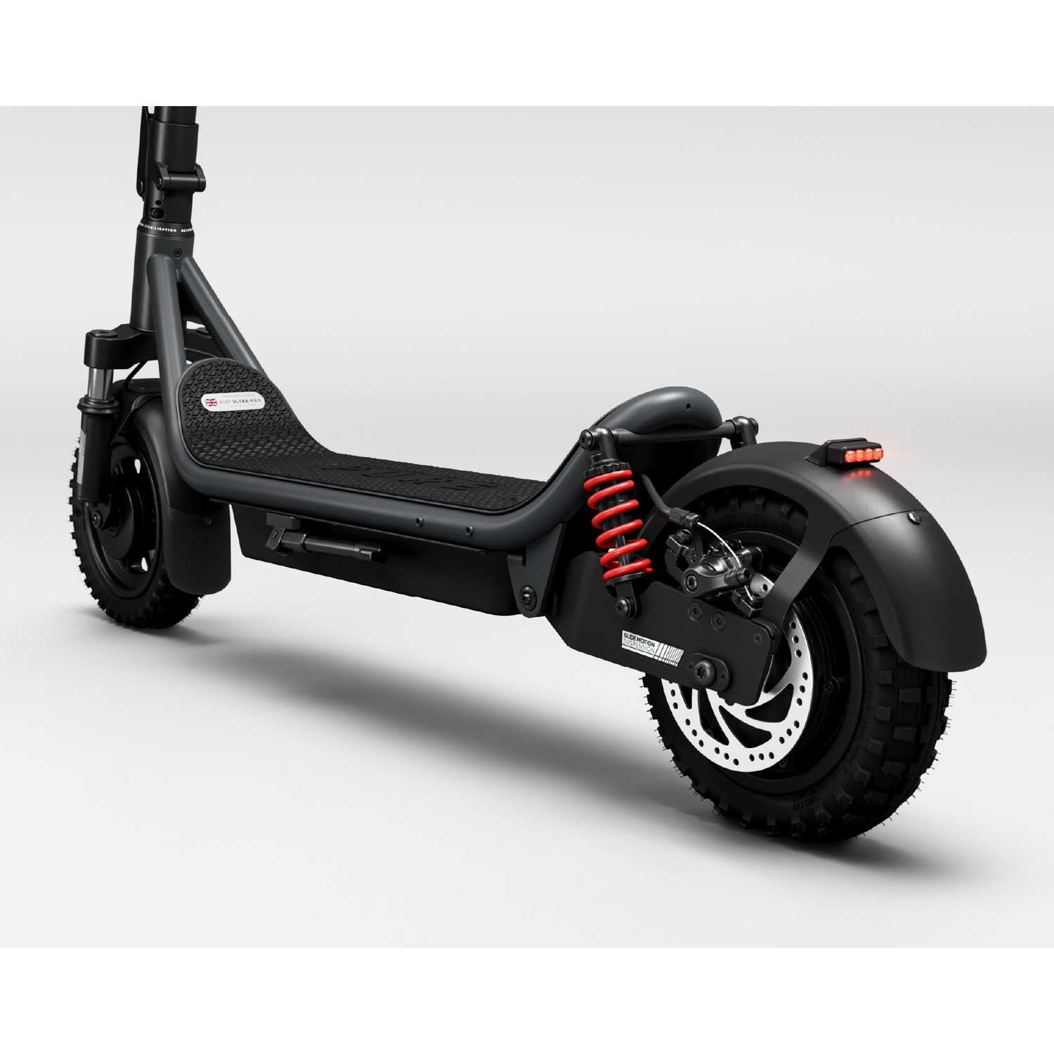 A black electric scooter with red rear suspension springs and disc brake against a plain white background.