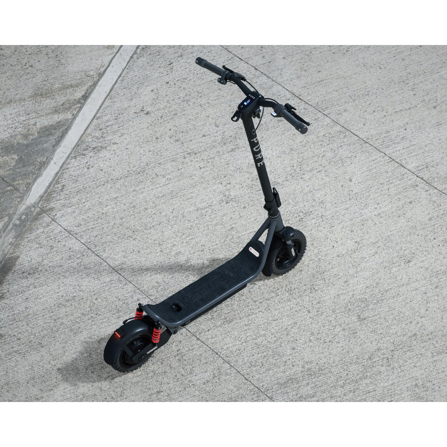 A gray electric scooter stands on a gray concrete floor.