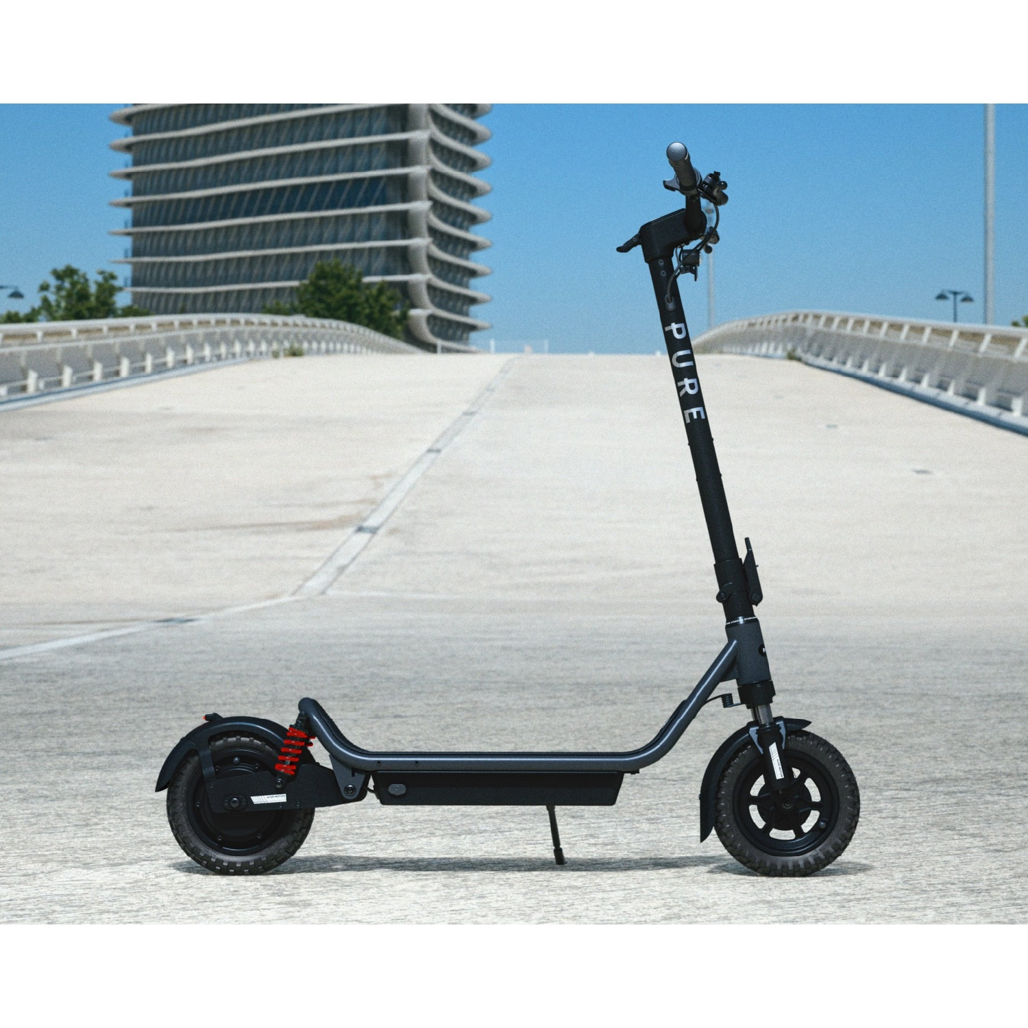 A black electric scooter stands on an empty road with a bridge and a modern building in the background.