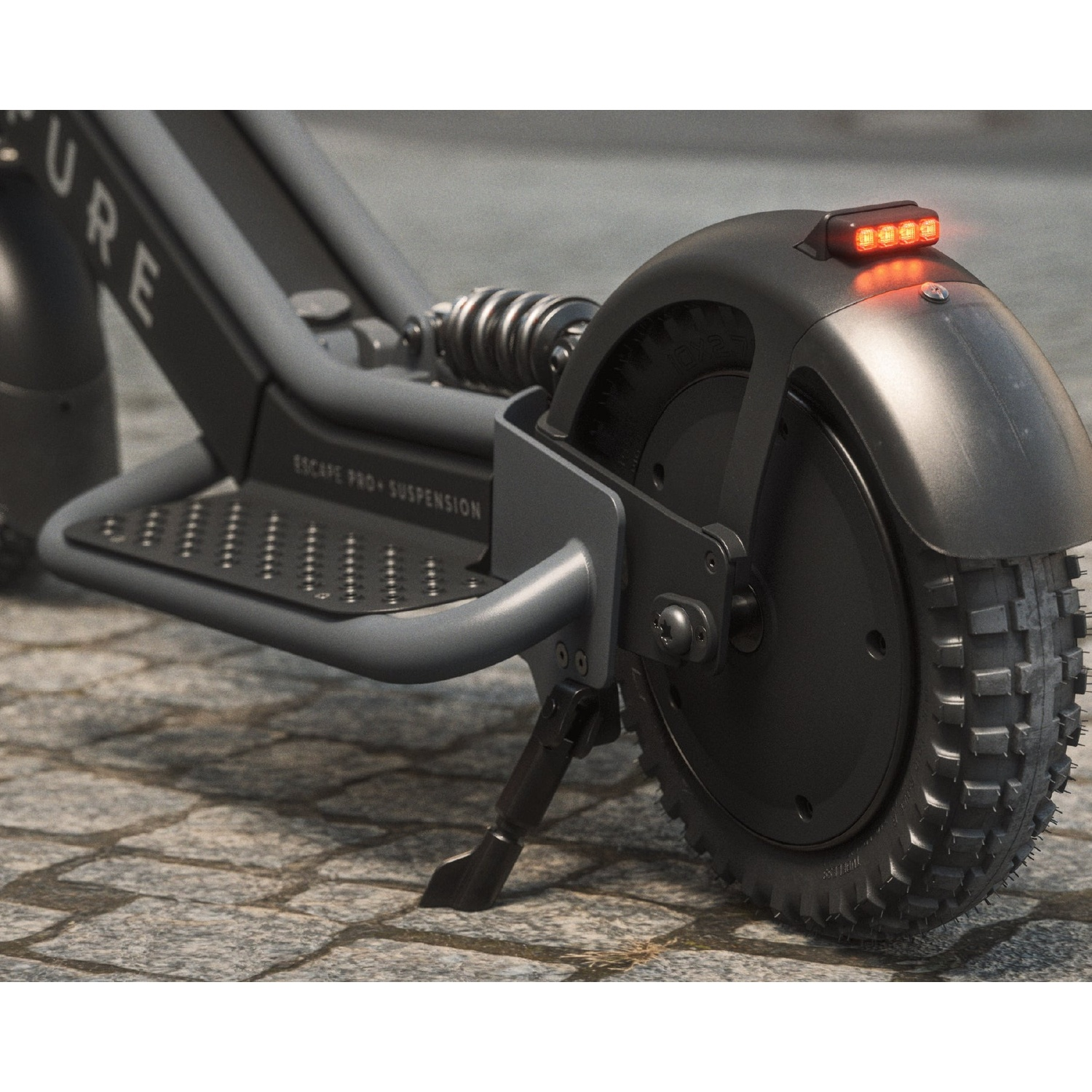 Close-up of the rear wheel, suspension, and glowing red taillight of an e-scooter on cobblestones.