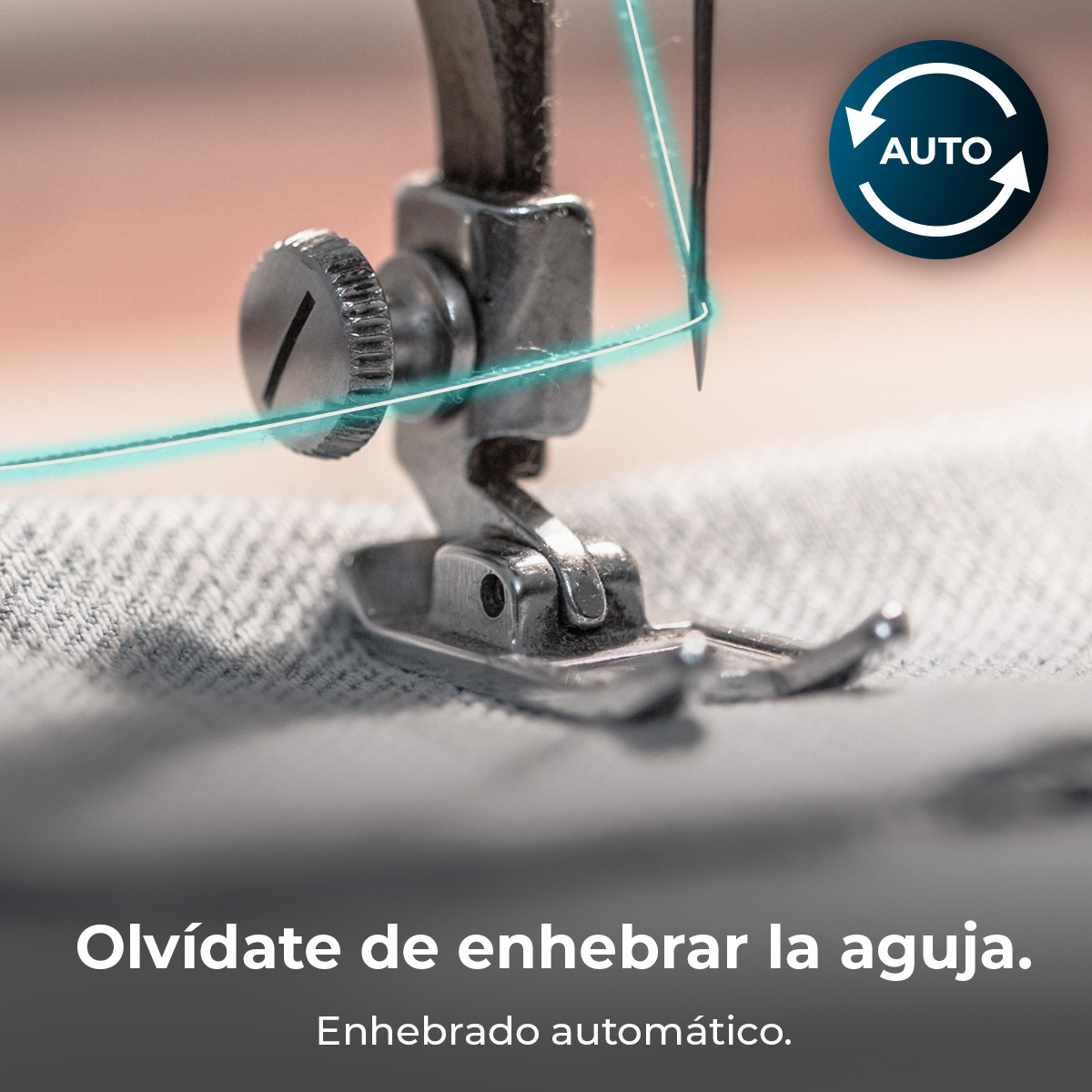 Aguja y pie de máquina de coser con hilo azul sobre tela gris. Icono auto arriba a la derecha.