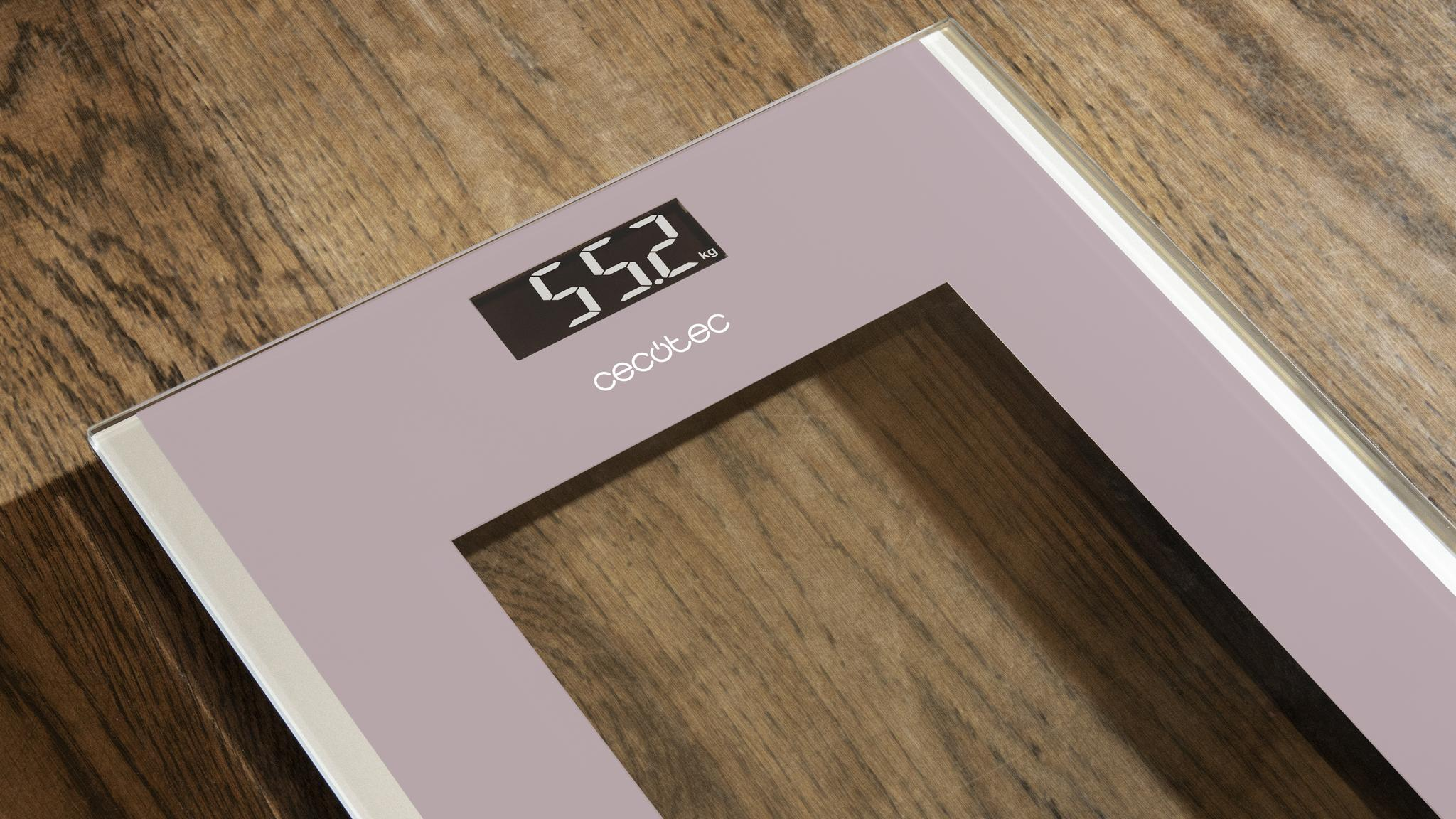 Báscula de baño digital rosa con logo de Cecotec y pantalla LCD en suelo de madera.