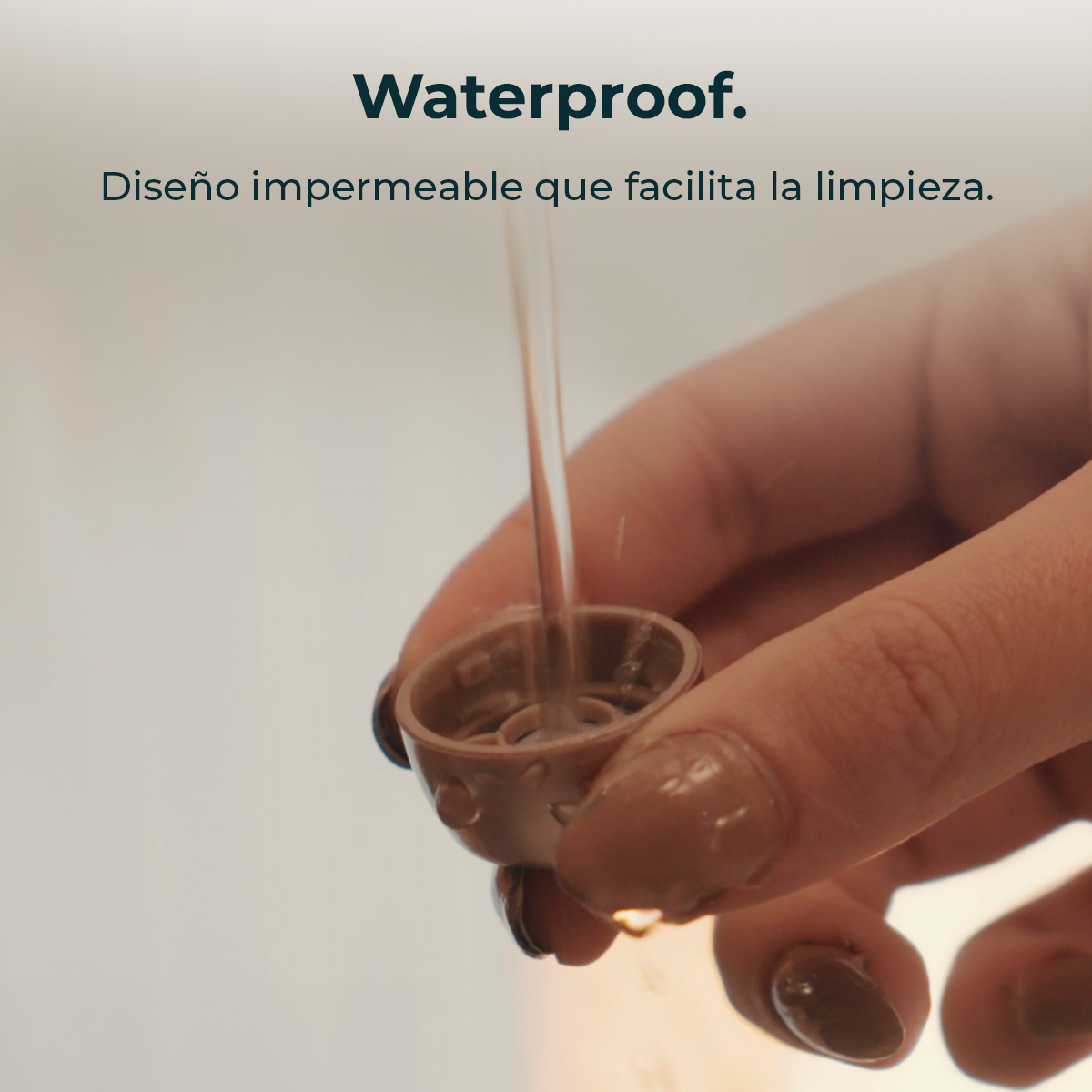 Diseño impermeable que facilita la limpieza, con agua cayendo sobre una tapa.